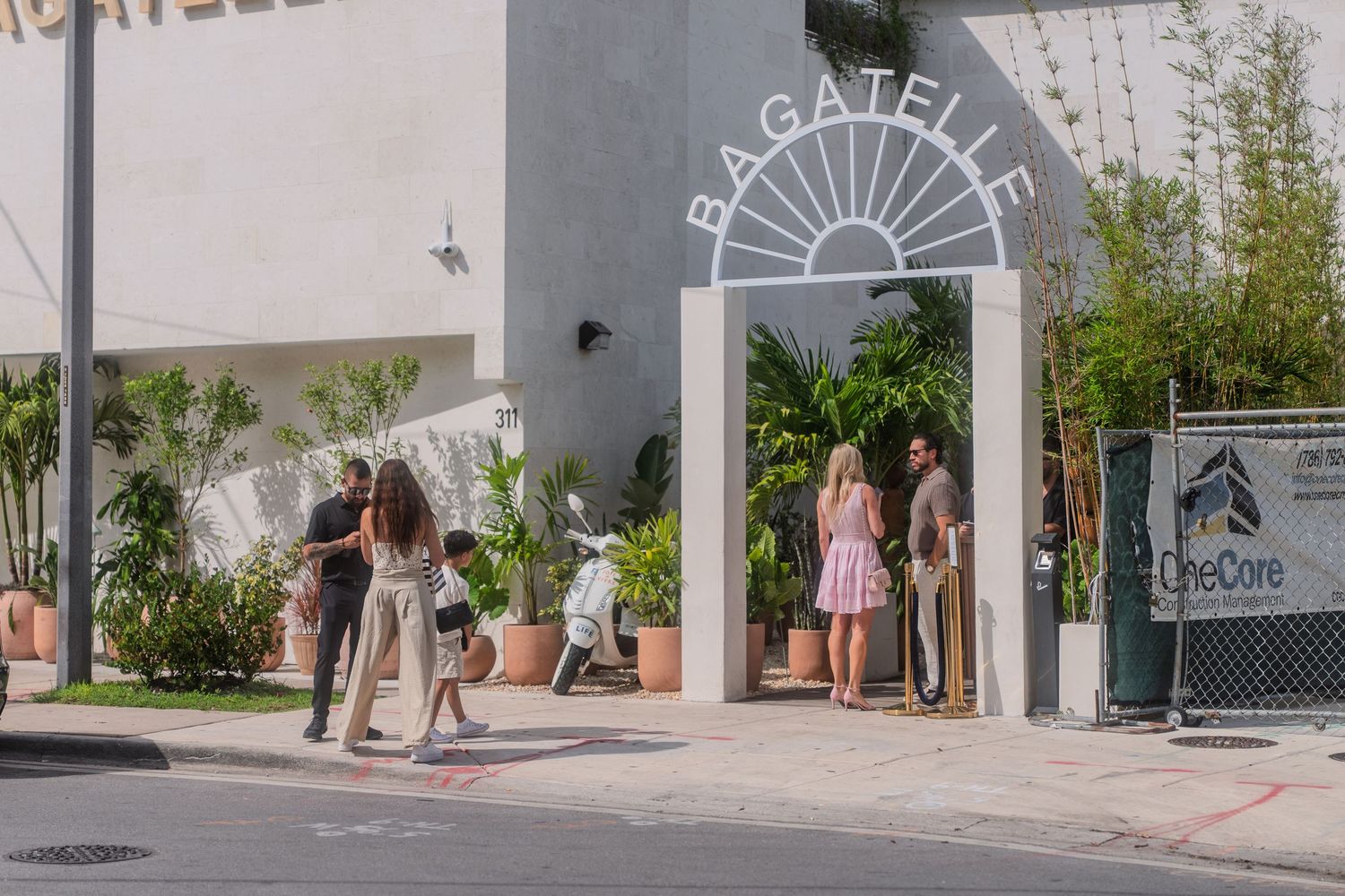 Guests arriving at the elegant Bagatelle restaurant arch entrance on a bright sunny day.