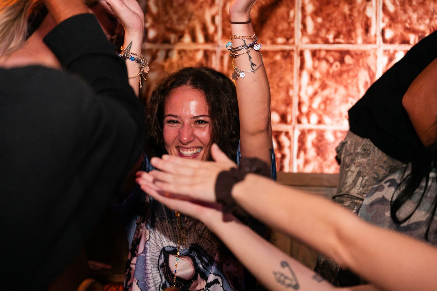 Happy woman smiling surrounded by friends at a lively indoor party.