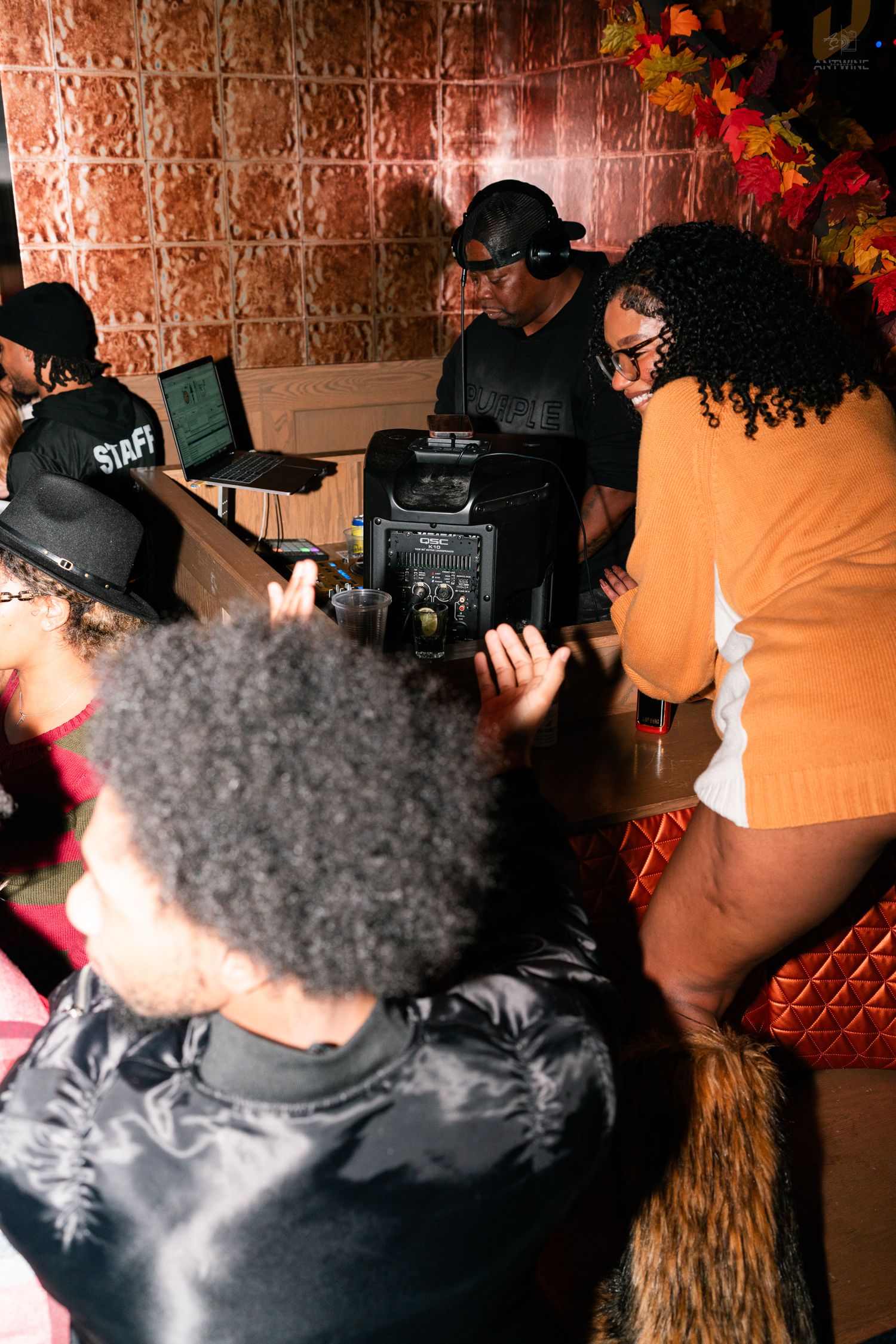 DJ and guests gathered around equipment at a fall-themed event at The Street Cincinnati.
