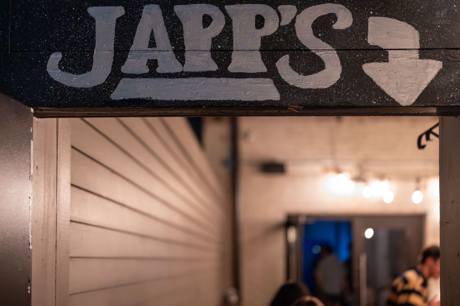 Japp's bar entrance sign with arrow pointing down, dimly lit interior visible in background.