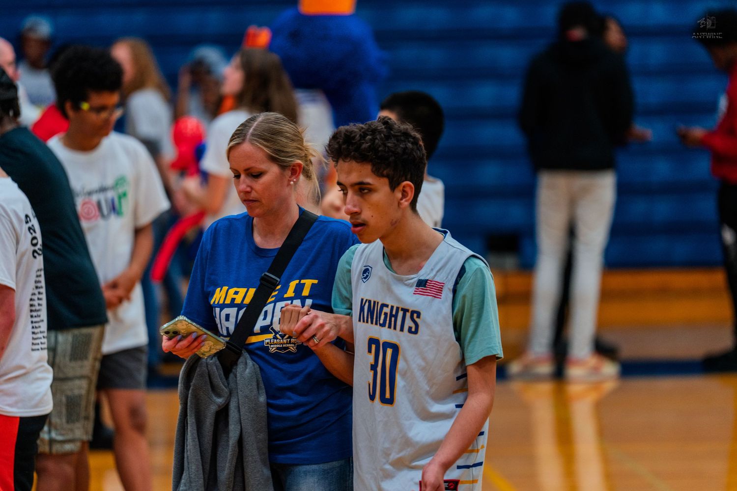 A basketball player wearing jersey number 30 talks with a coach on an indoor court during a game.