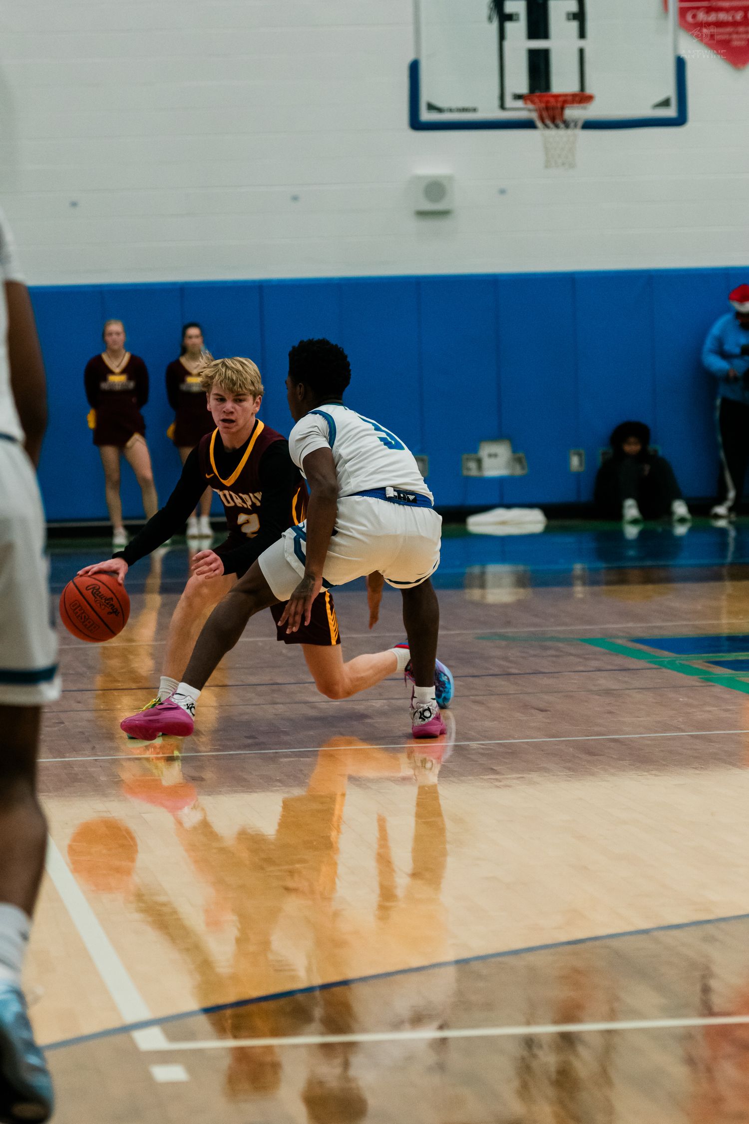 Turpin basketball player dribbles past Warriors defender on shiny hardwood court during game.