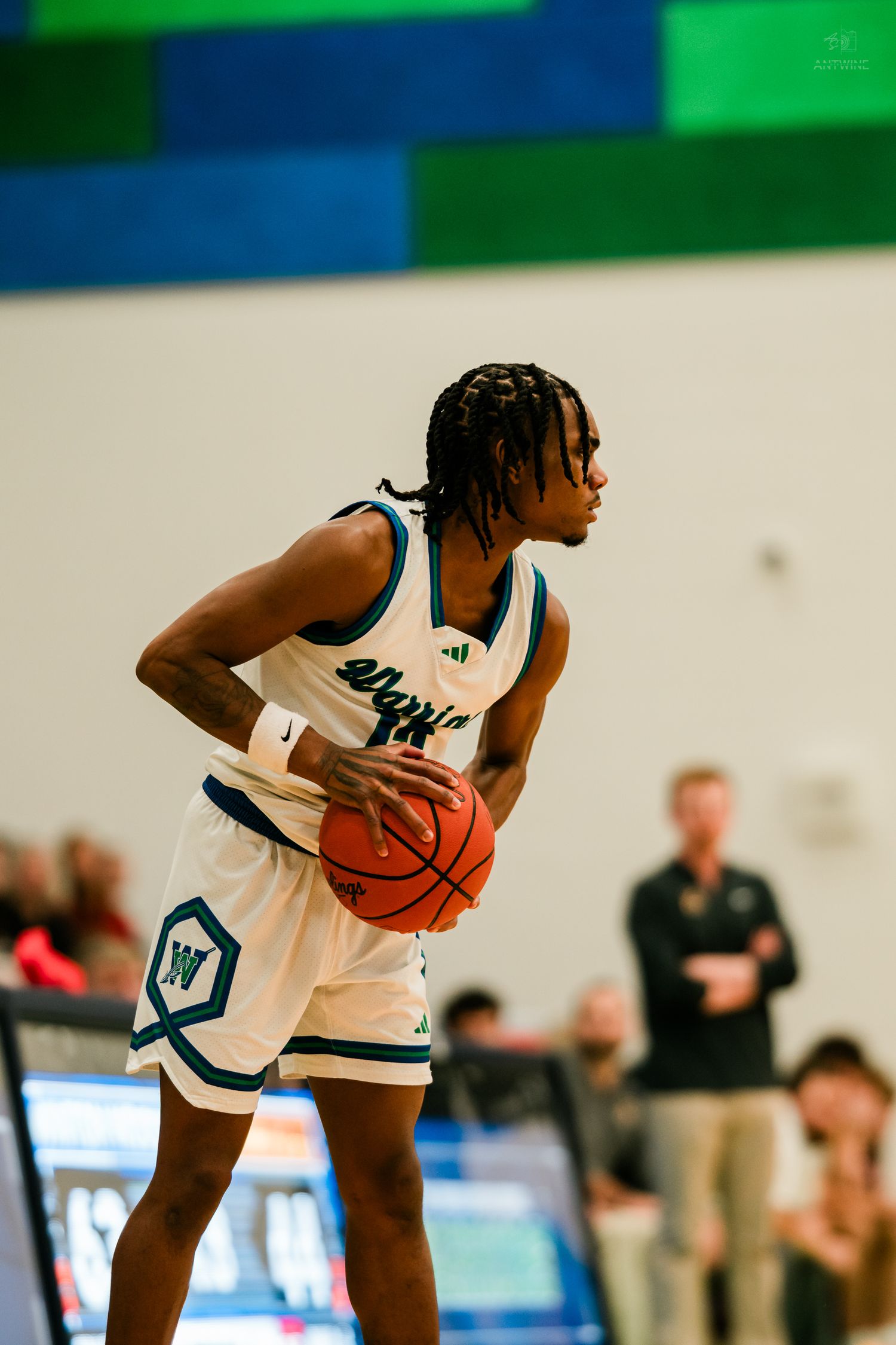 Warriors basketball player holds the ball at chest level while preparing to make a play on the court.