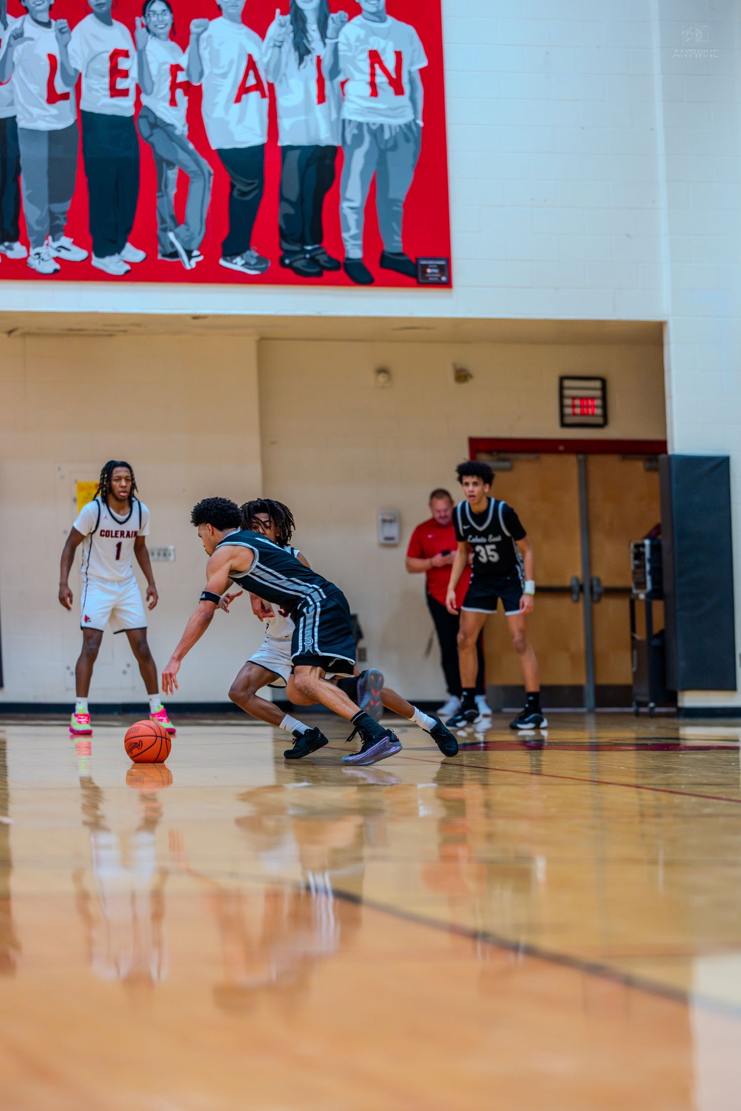 Two basketball players battle for the ball during a high school game at Colerain gym.