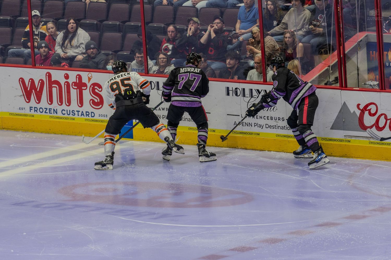 Hockey players compete for the puck during an intense minor league ice hockey game.