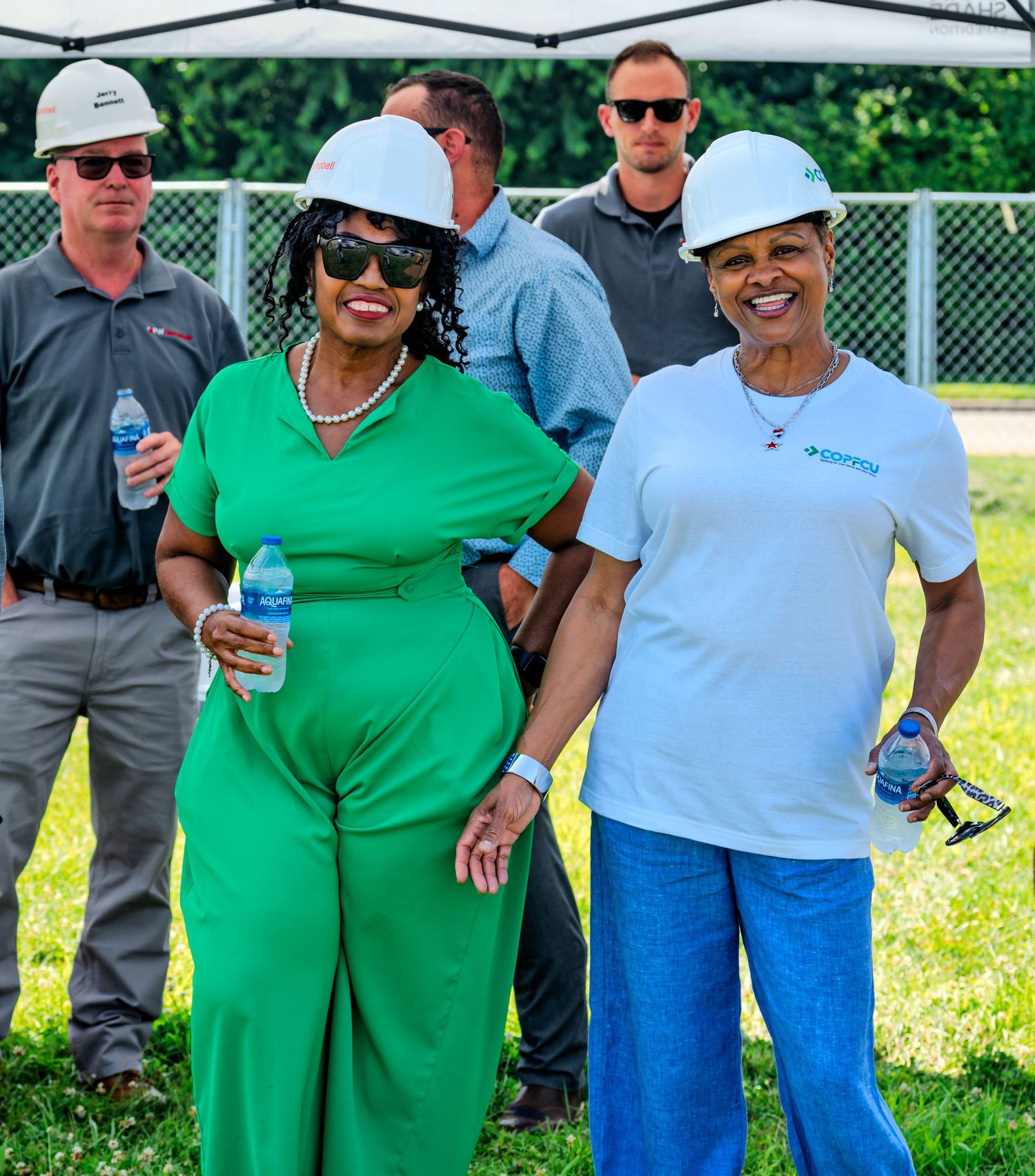 Two smiling women in hard hats pose together at COPFCU Hamilton groundbreaking celebration event.