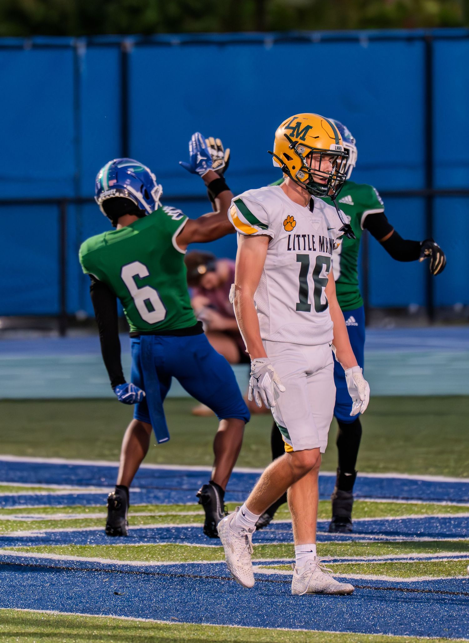 Little Miami football player #16 in yellow uniform reacts during a high school football game.
