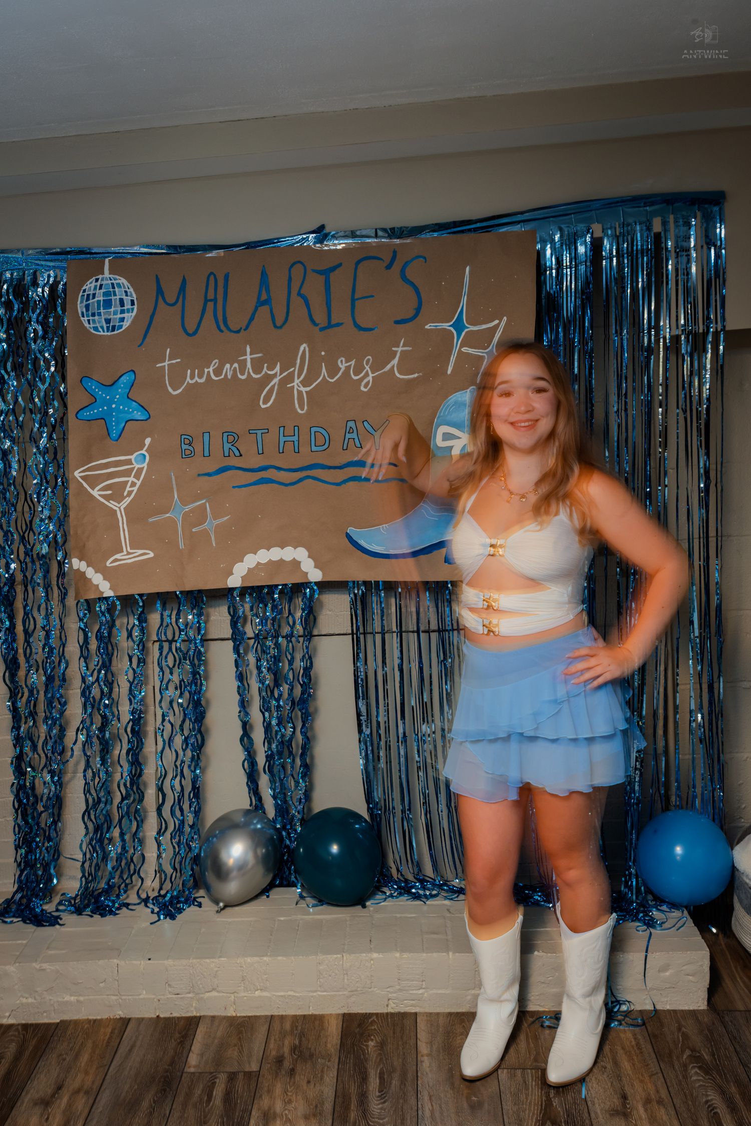 Birthday girl in white crop top and blue ruffle skirt posing at Malarie's 21st birthday party.