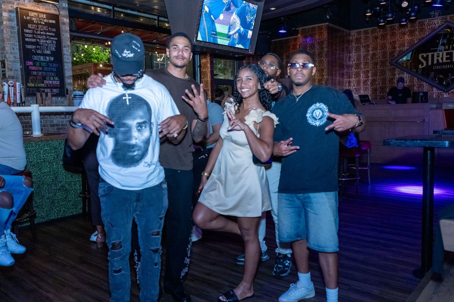Five friends smiling and posing together inside Stretch Bar restaurant and lounge.