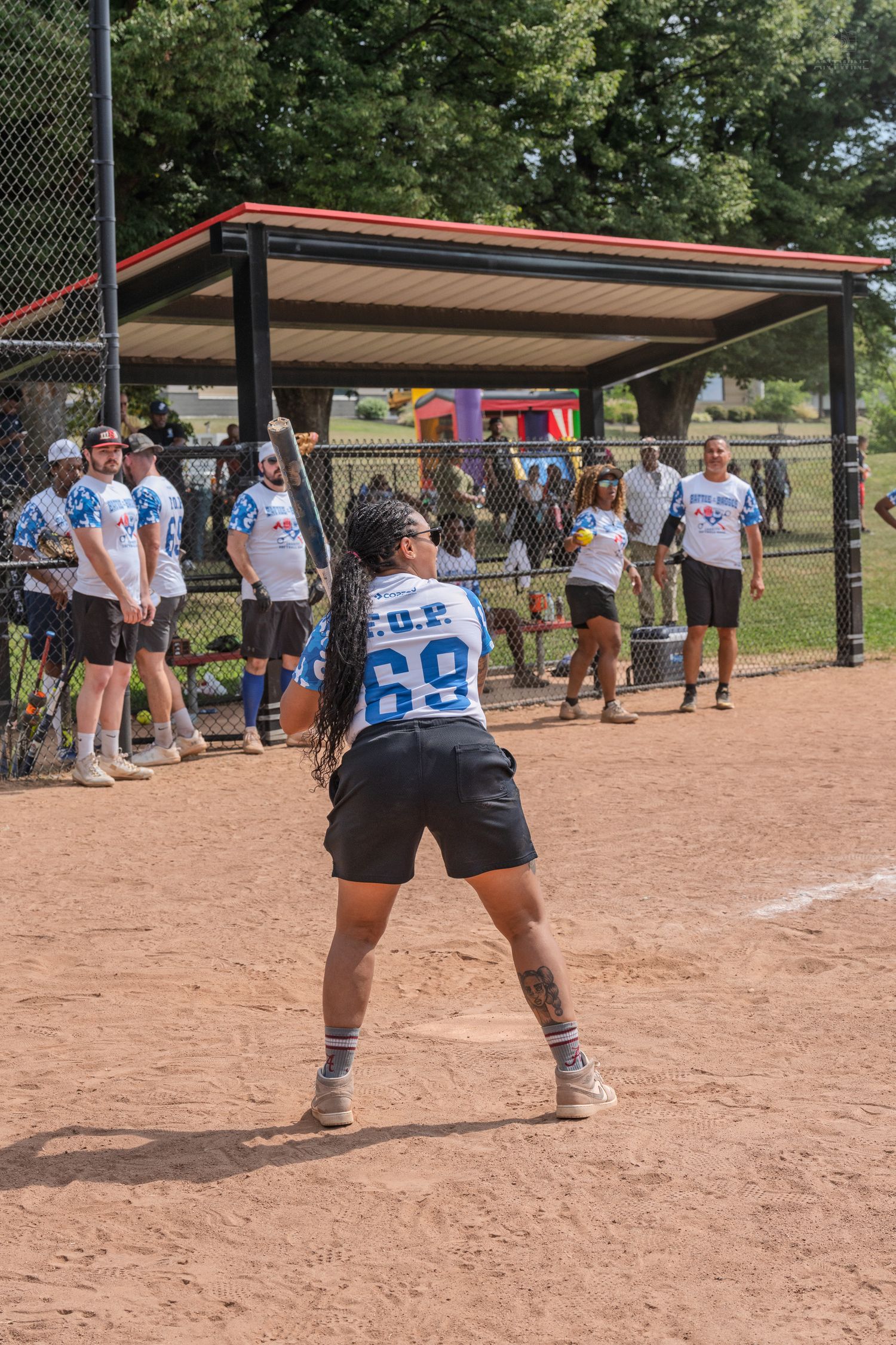 Female softball player in number 69 jersey ready to field during a recreational league game.