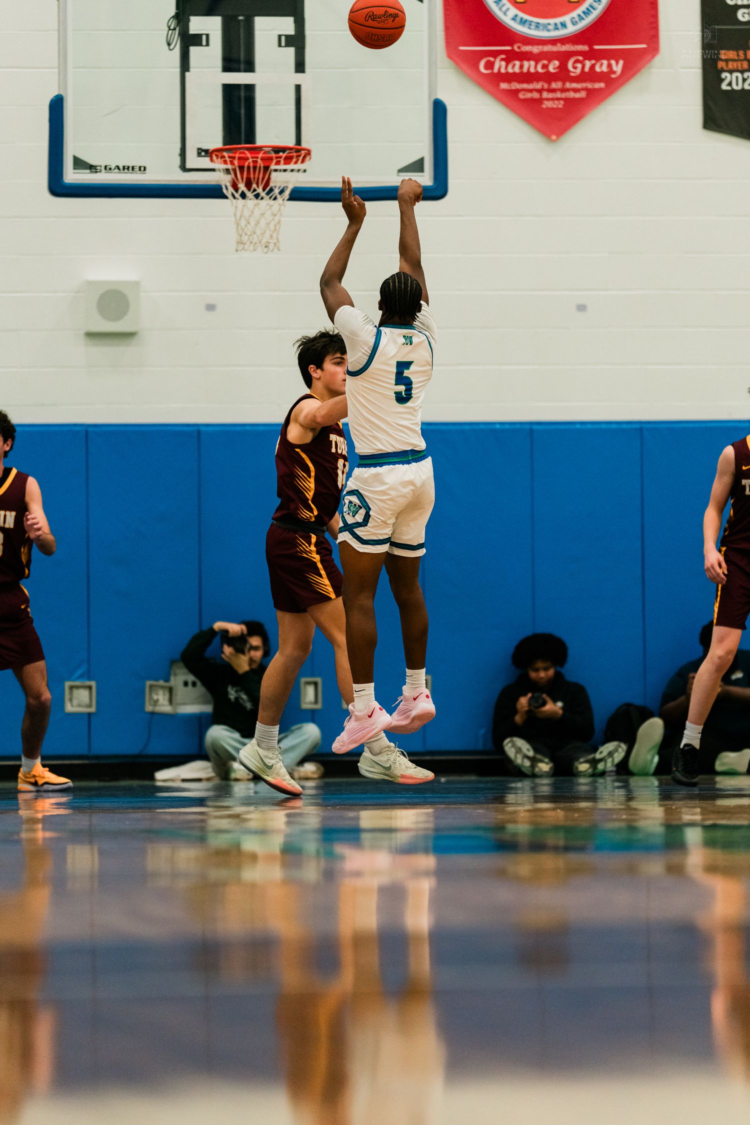 Player #5 in white uniform shoots over Turpin defender during high school basketball game in blue gymnasium.