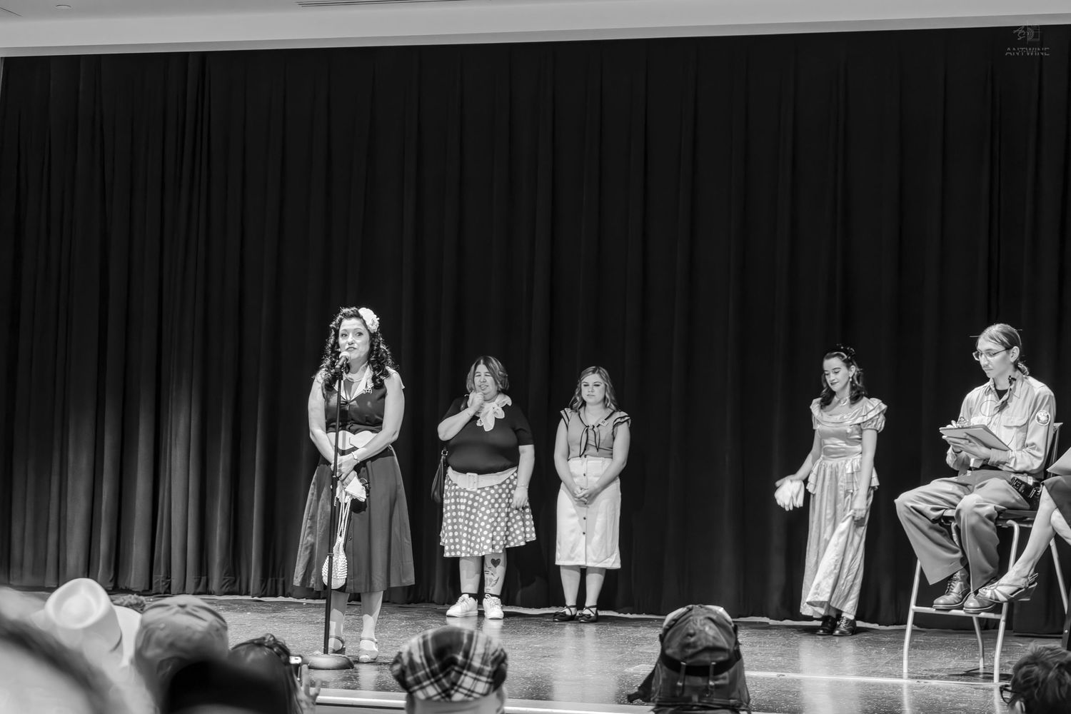 Black and white photo of five performers on stage during a school or community theater production.