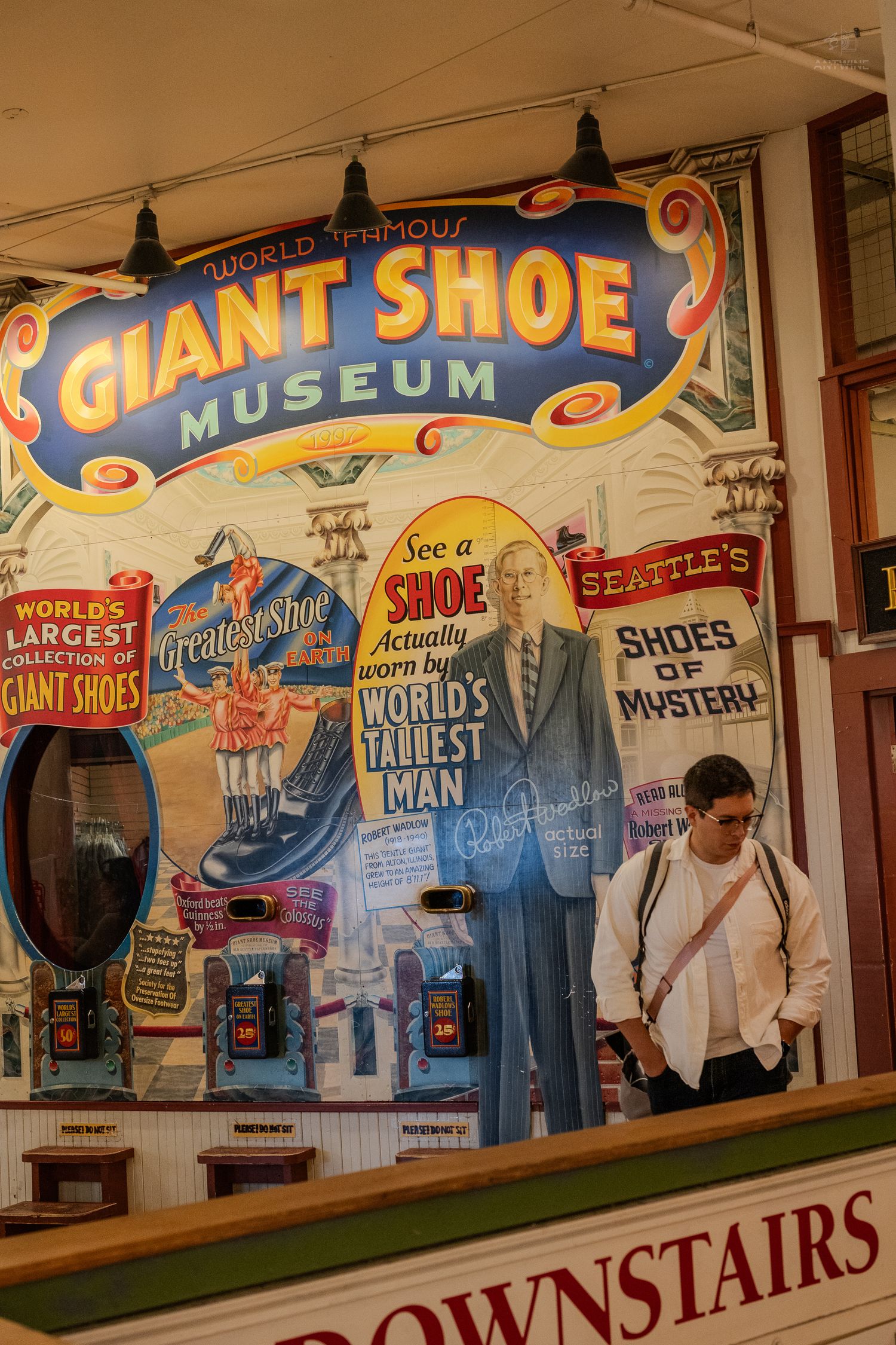 Tourist reading the World Famous Giant Shoe Museum sign at Pike Place Market in Seattle.