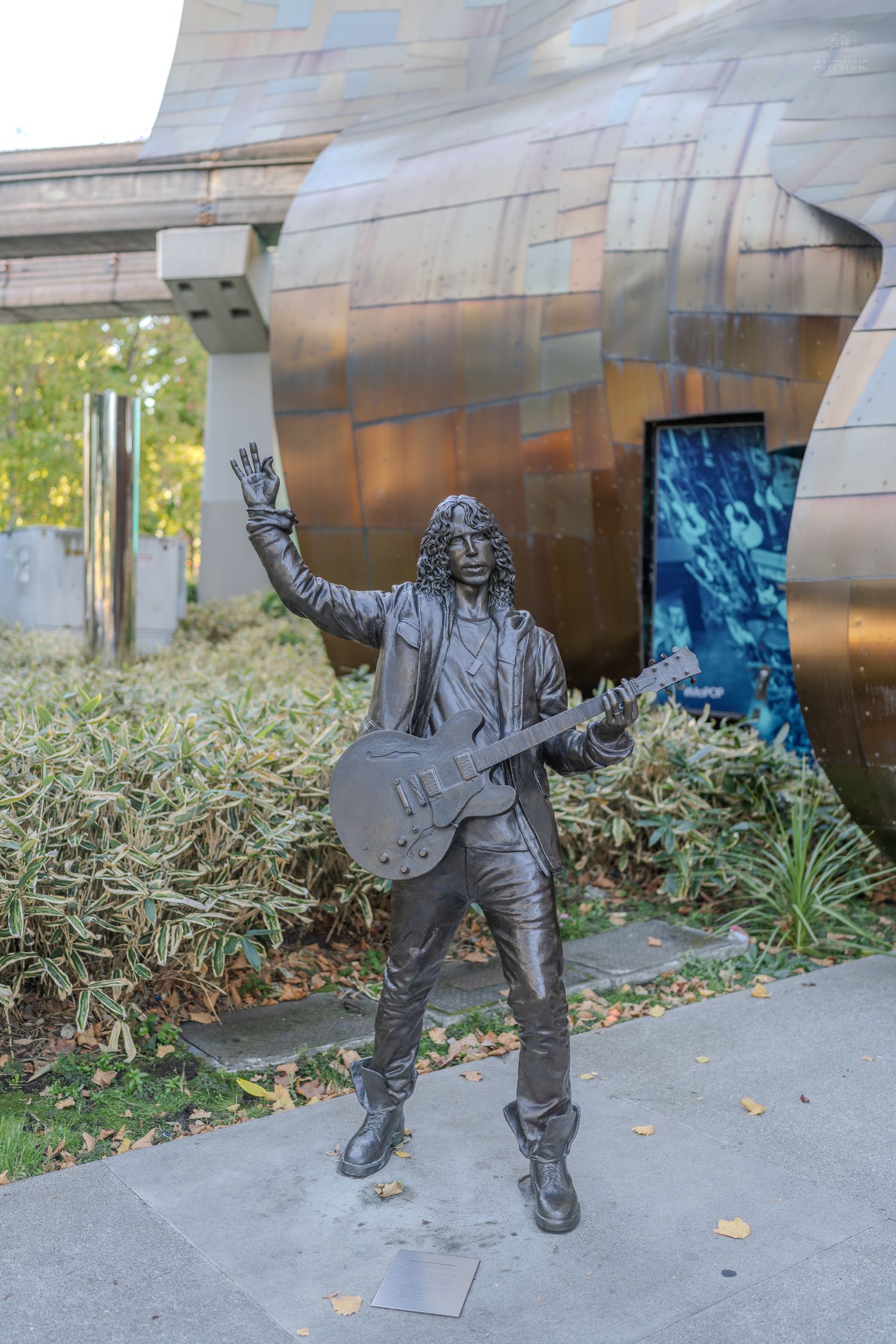 Bronze statue of a rock guitarist with raised hand outside the Museum of Pop Culture in Seattle.