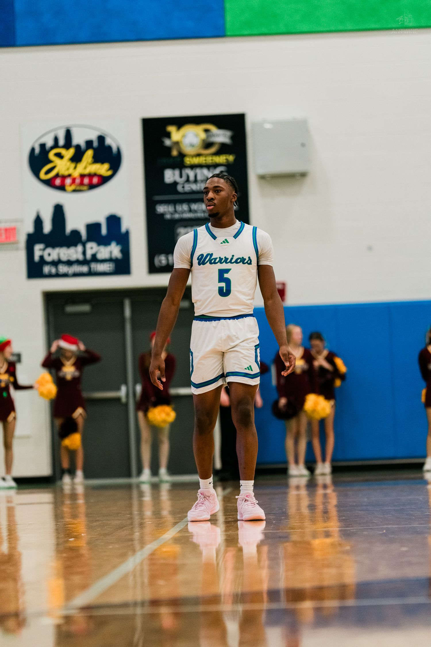 Warriors number 5 player stands confidently on court with Turpin cheerleaders visible in background.
