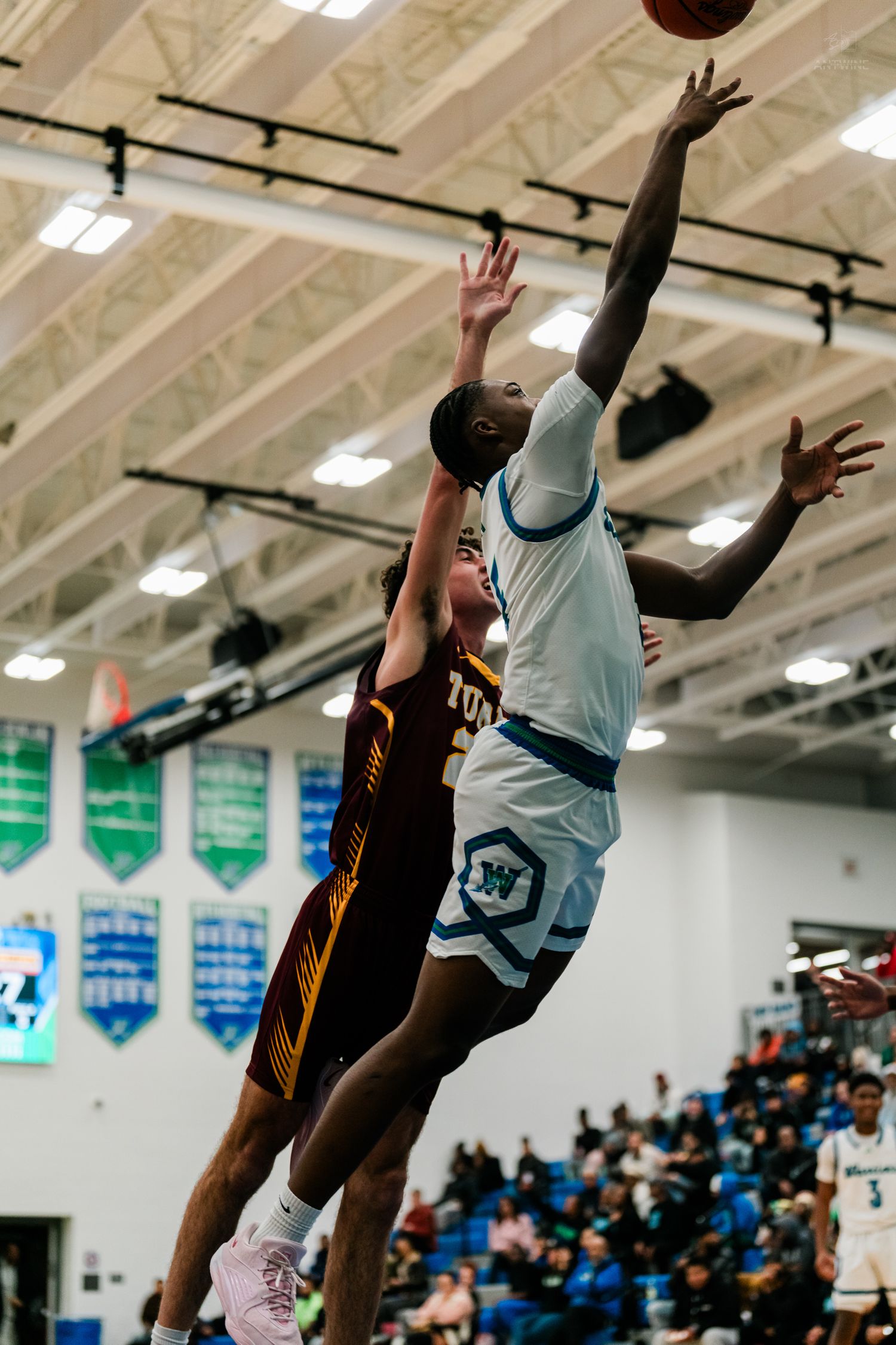 Warriors player elevates for a shot over a Turpin defender during a competitive high school basketball game.