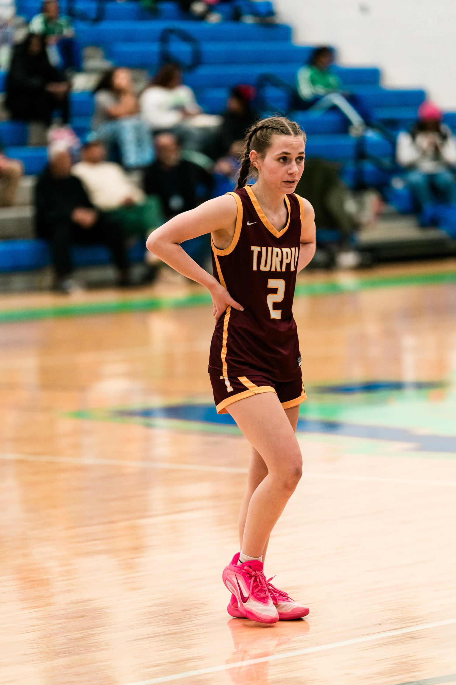 Female basketball player #2 in maroon Turpin jersey stands on court during girls high school basketball game.