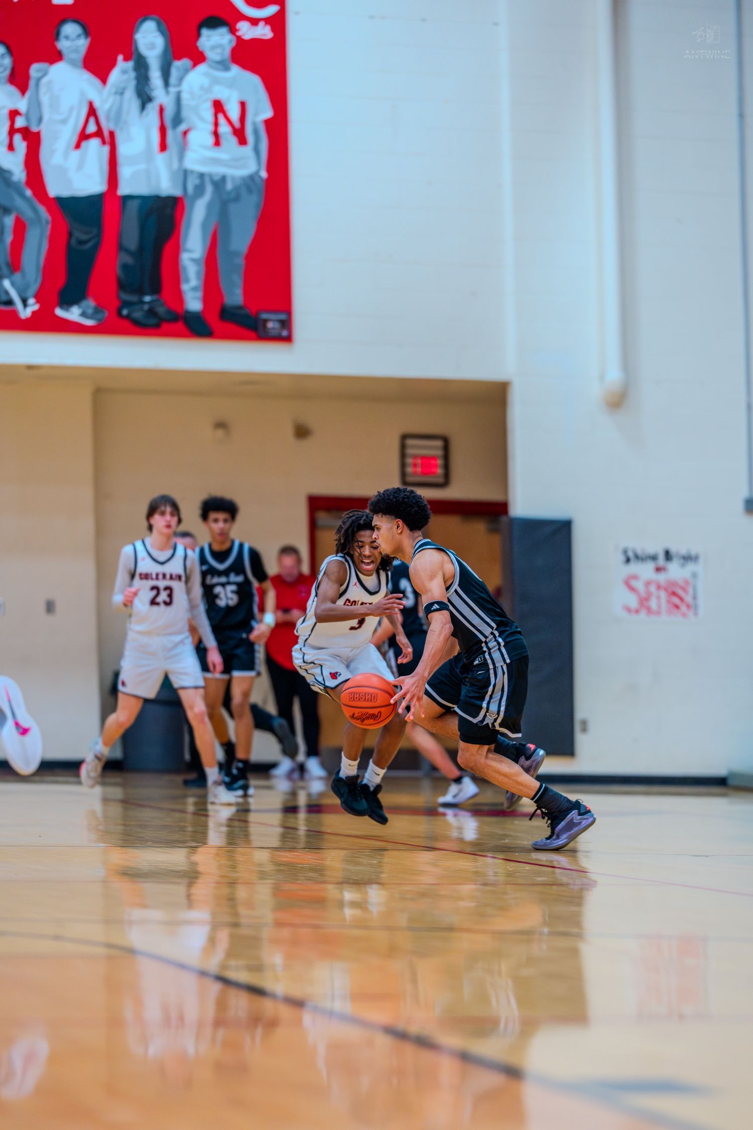 Basketball player drives past a defender during a high school game at Colerain gym.