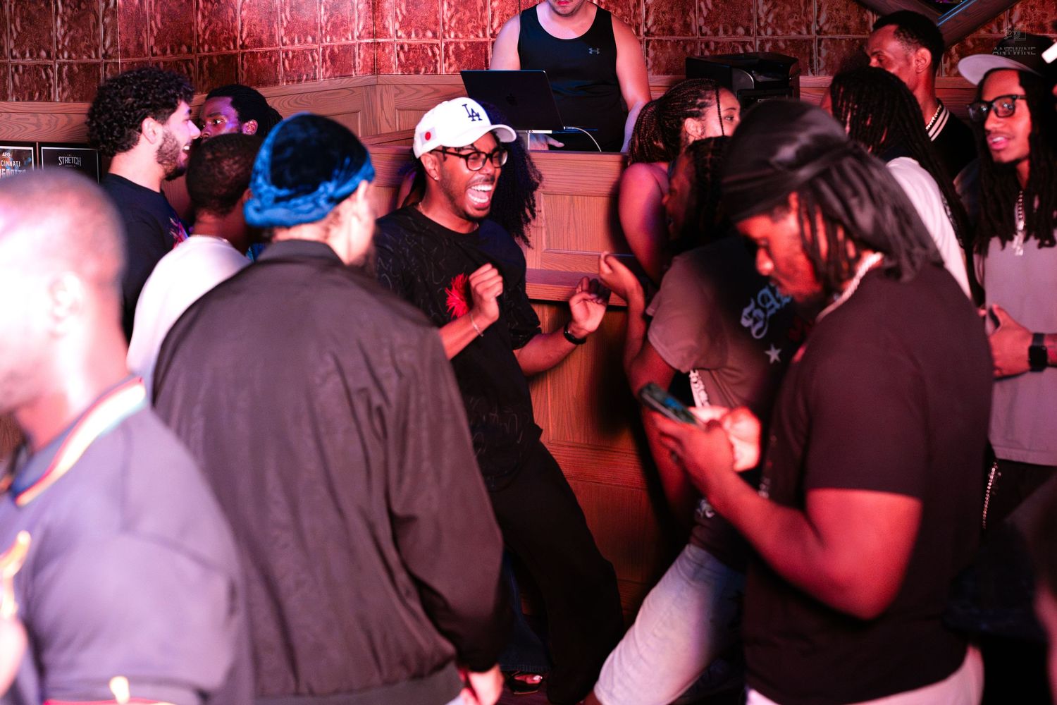 Diverse group of people dancing and socializing at an energetic nightclub party.