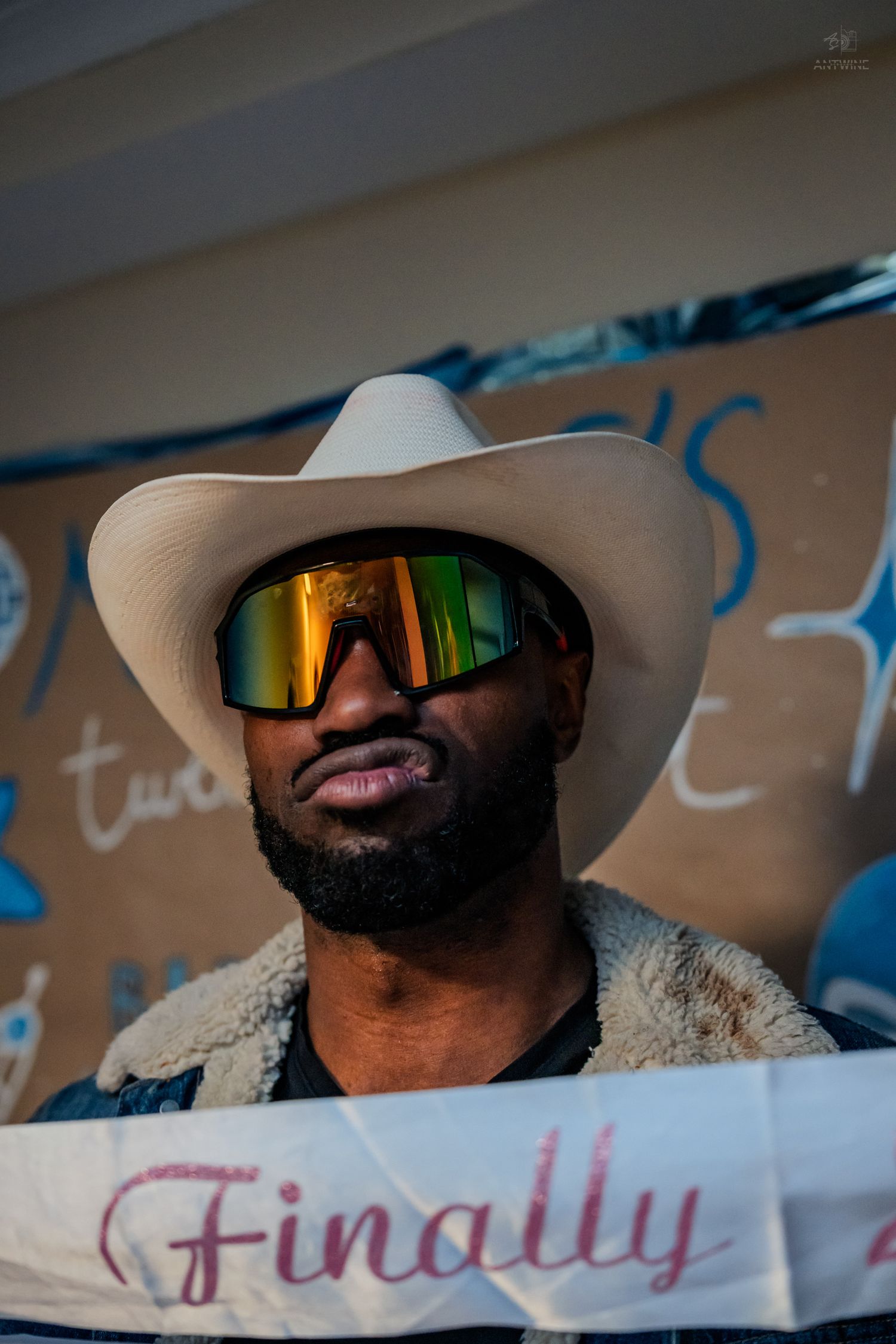 Close-up of man in white cowboy hat and reflective sunglasses at a 21st birthday party.