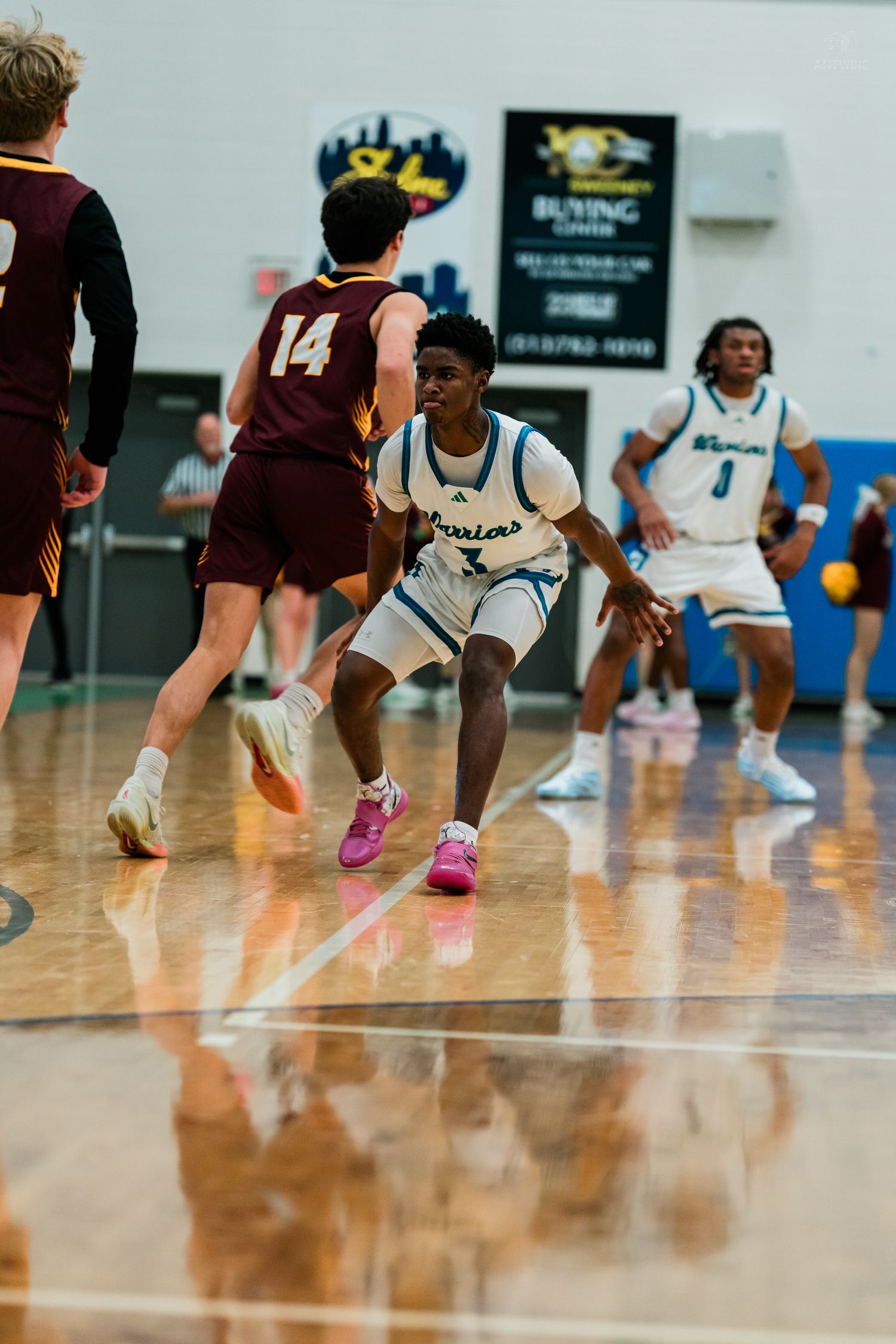 Warriors player number 3 plays defense against Turpin player number 14 during a high school basketball game.