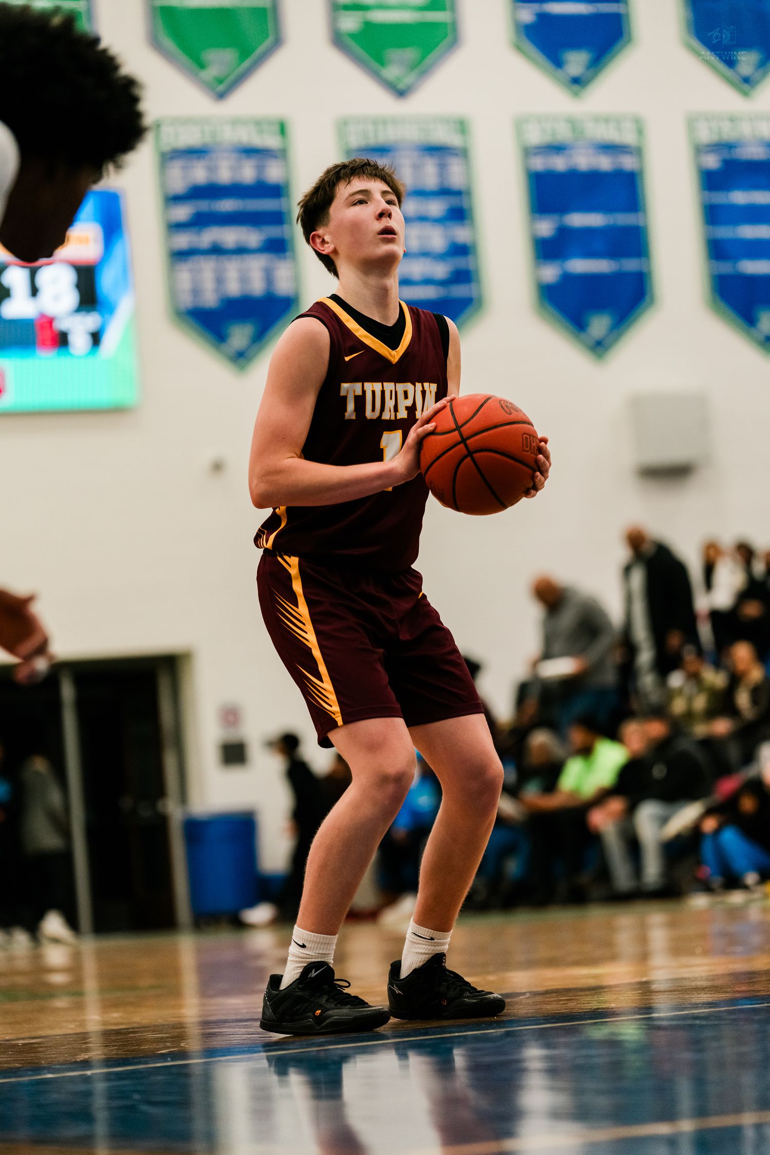 Turpin high school basketball player #1 prepares to shoot during a game in a packed gym.