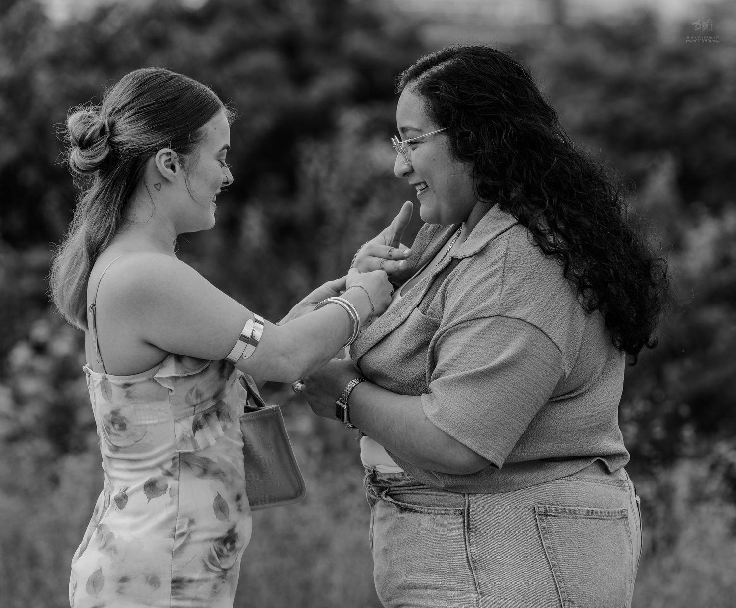 Two women sharing a happy emotional moment together in black and white outdoor portrait photography.