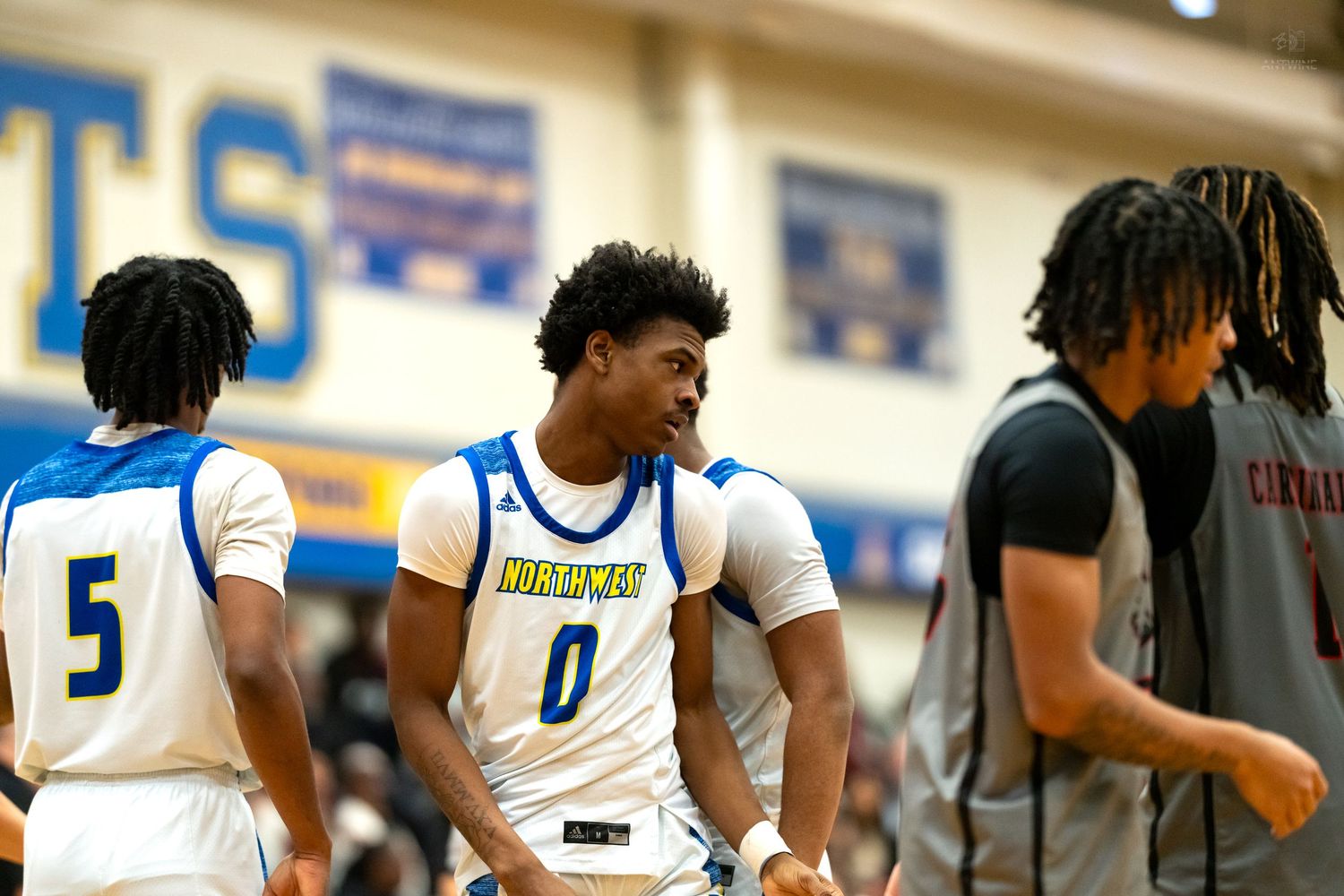 Basketball player number 0 in blue Northwest jersey celebrates with teammates during game.