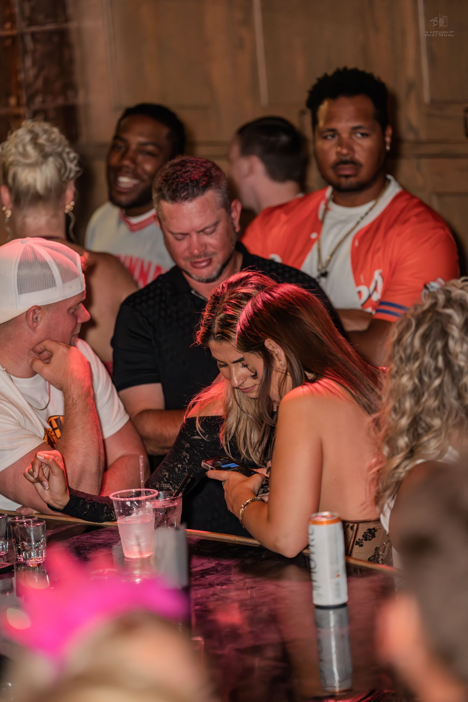 Group of people socializing around a table at a lively nightclub or bar event.