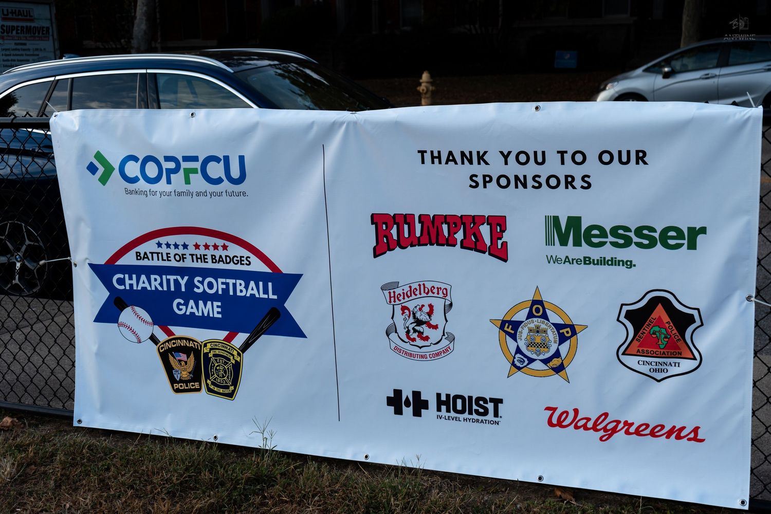Banner for COPFCU Battle of the Badge Charity Softball Game thanking sponsors including Walgreens and Messer.