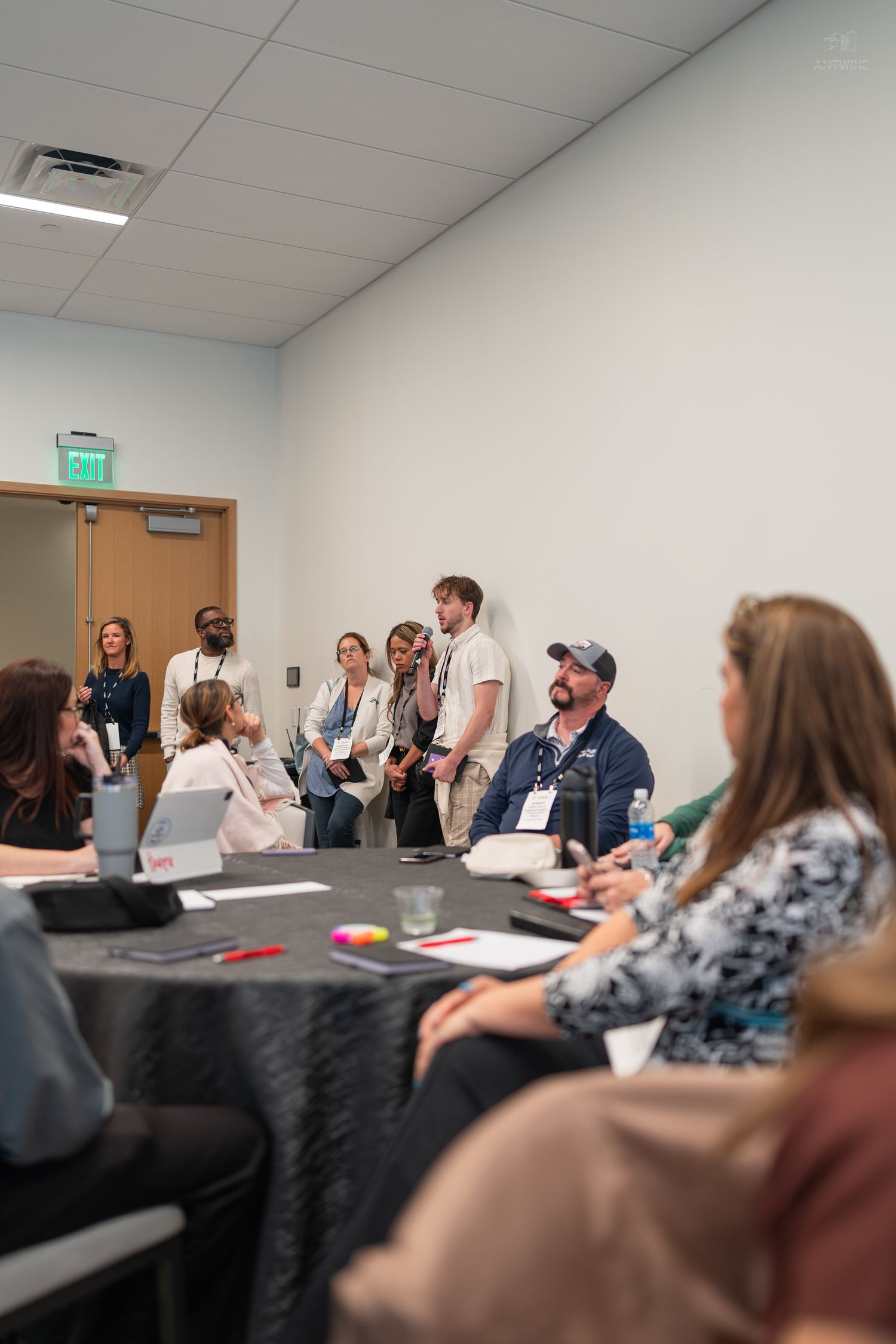 Group of diverse professionals gathered in a conference room during an indoor meeting or workshop.