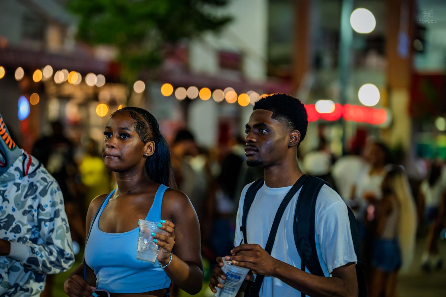 Young couple standing together at an outdoor nighttime festival event.