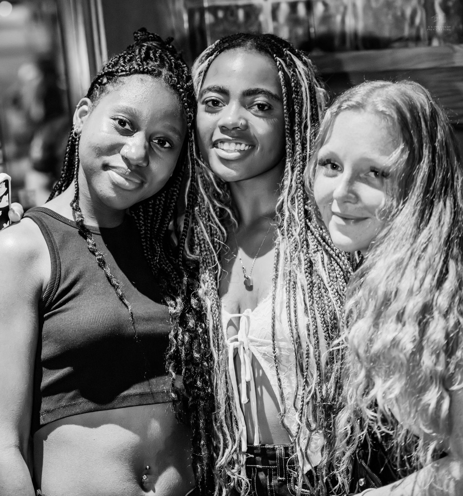 Black and white portrait of three smiling young women posing together.