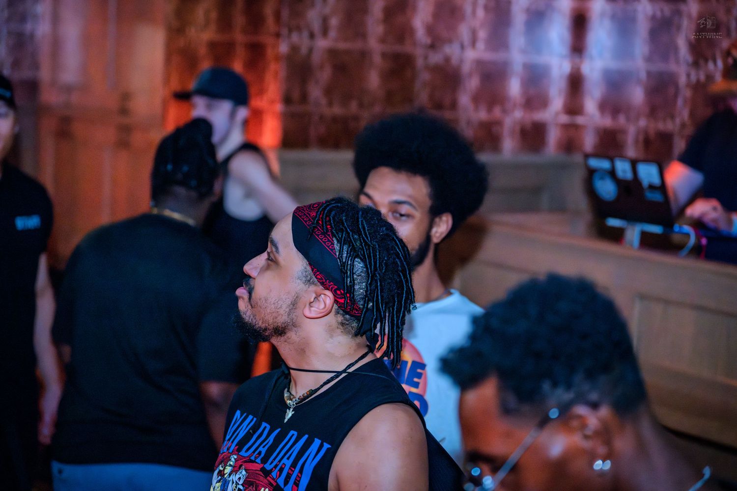Group of people with natural hairstyles gathered in a dimly lit nightclub venue.