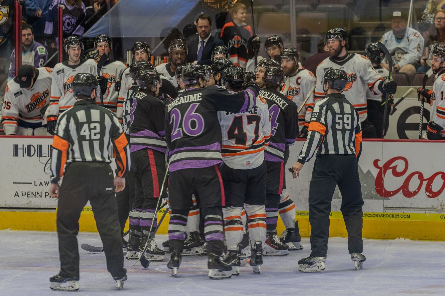 Players from two hockey teams cluster together on the ice in a heated altercation during a game.