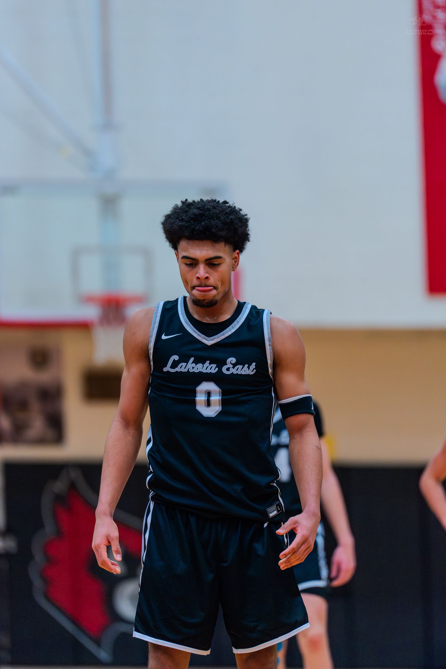Lakota East basketball player wearing number 0 jersey walks on court during a high school game.