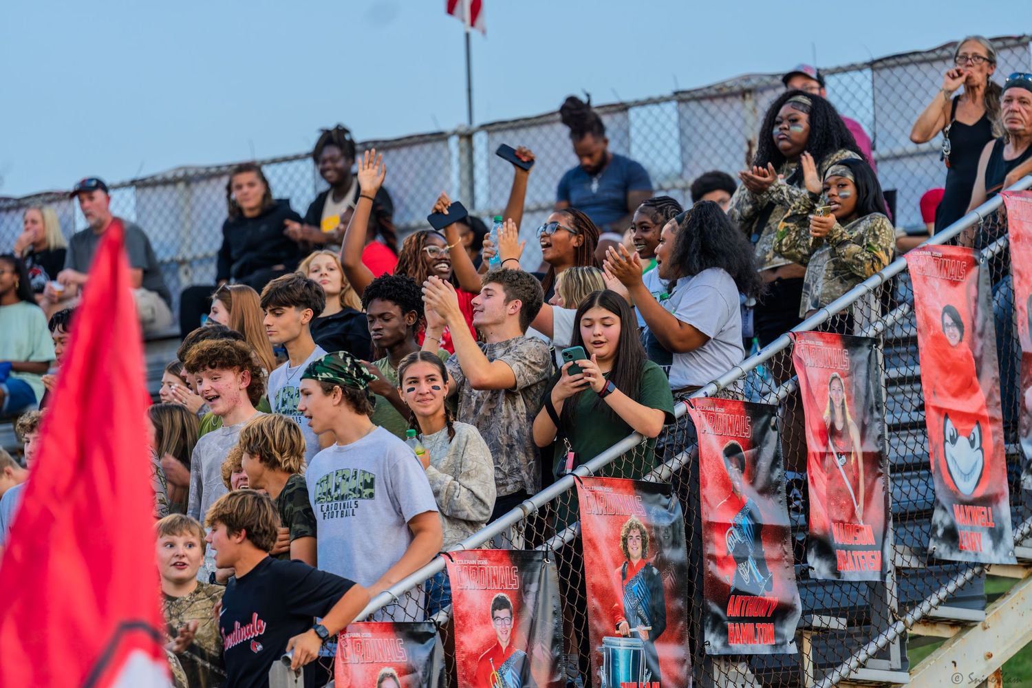 Enthusiastic fans cheer in the bleachers at a Colerain high school football game.