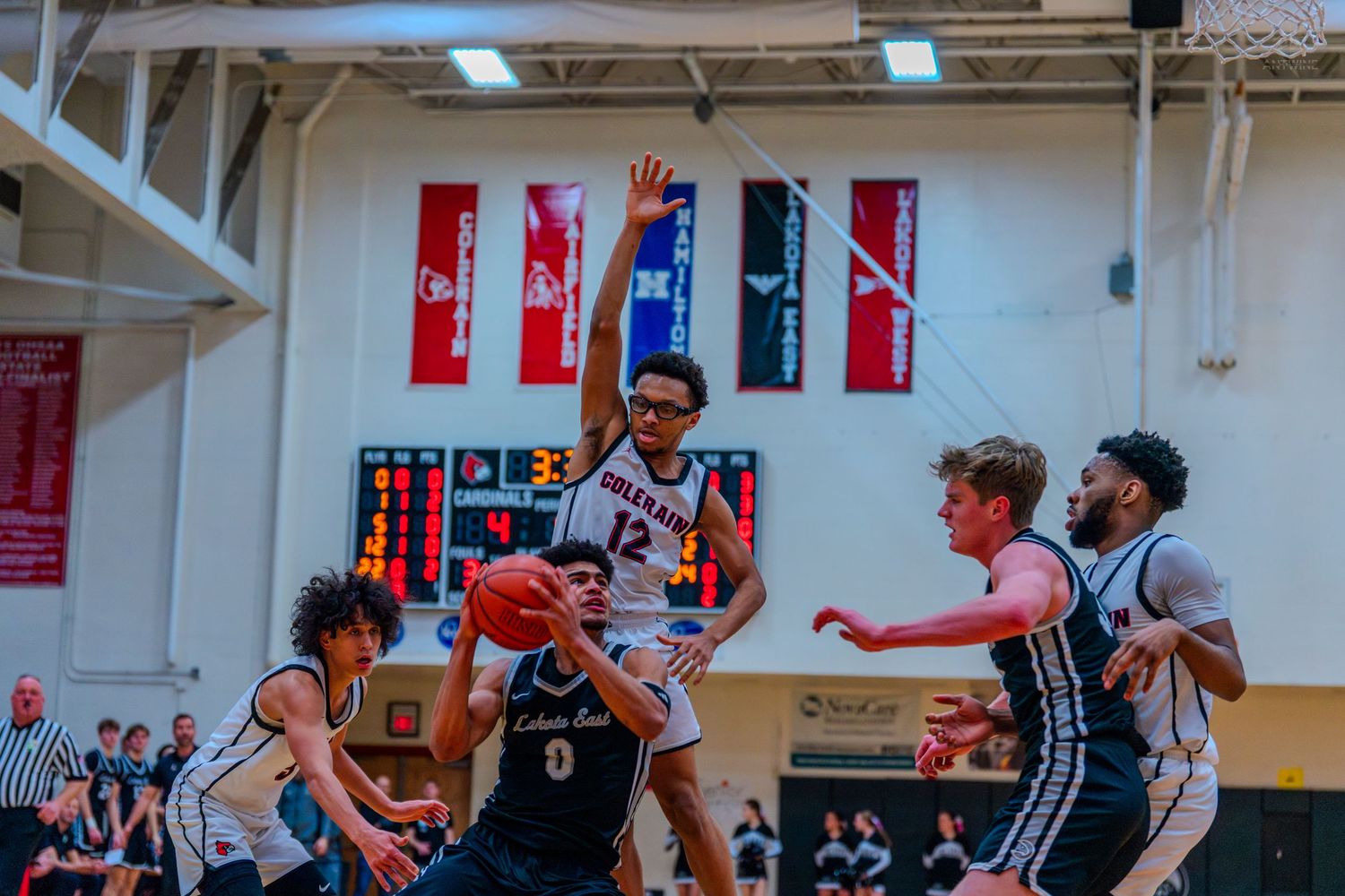 Lakota East #0 passes the ball under pressure during a high school basketball game.