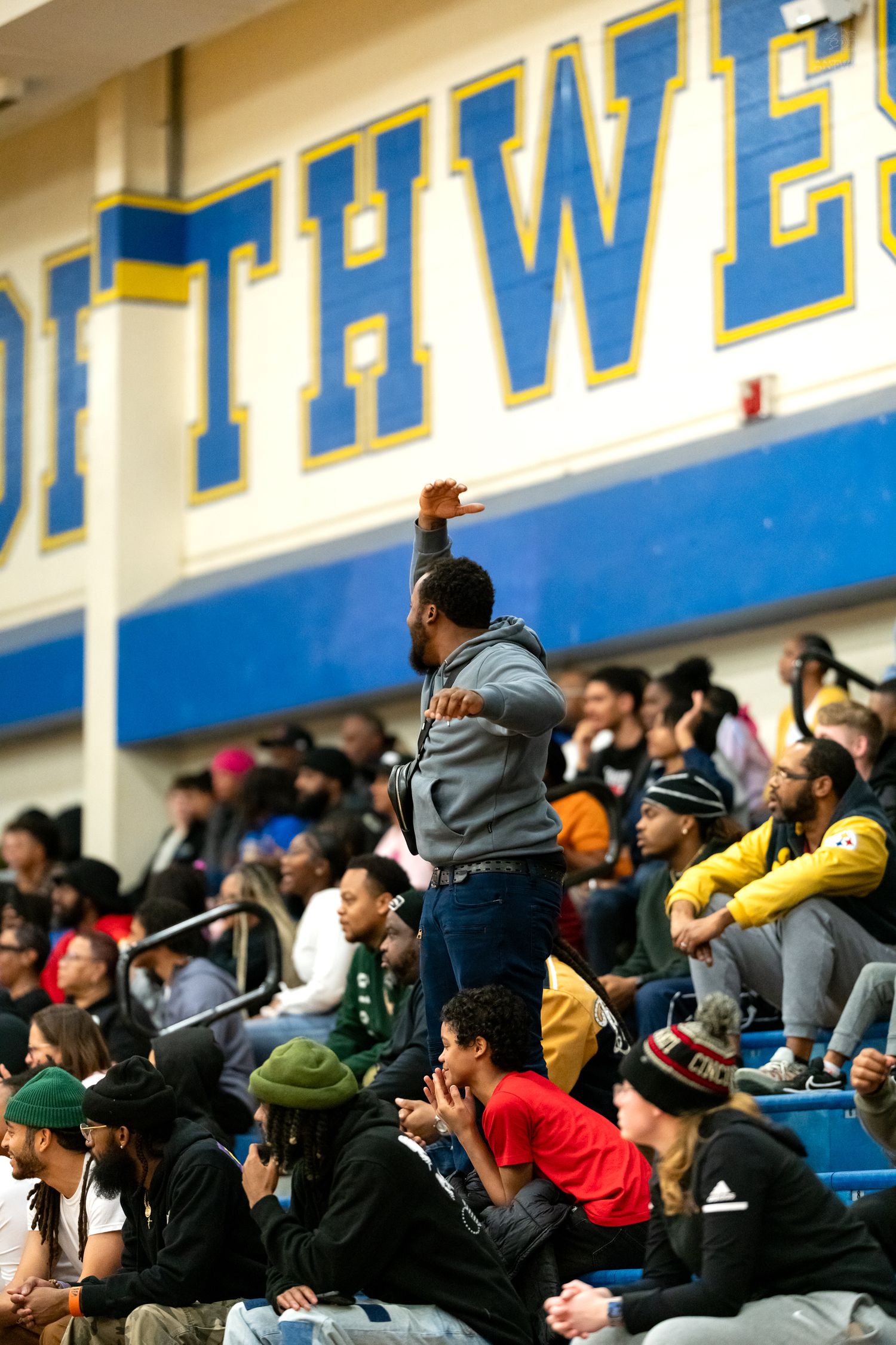 Energetic crowd cheers in the stands at a Southwest high school basketball game.