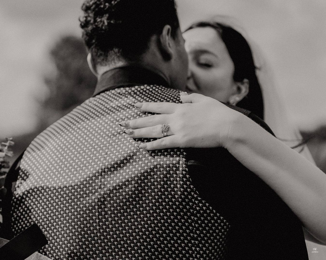 Black and white photo of bride and groom sharing romantic kiss at wedding.