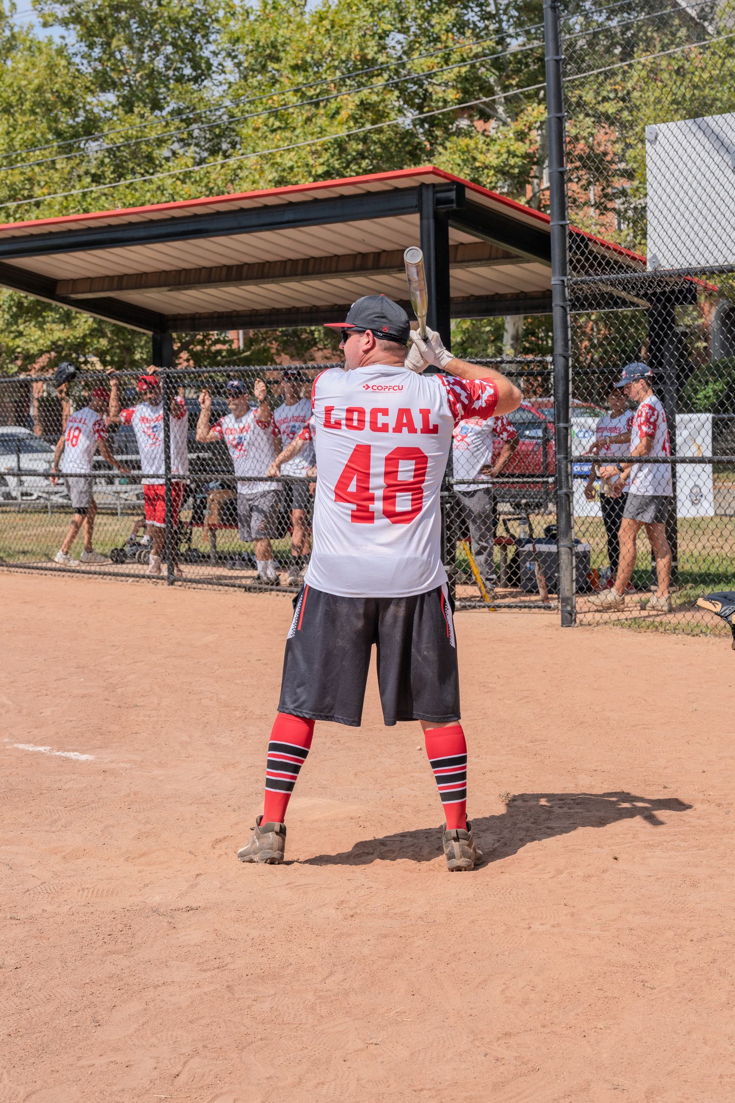 Softball player in Local 48 jersey standing on dirt field during a recreational game.