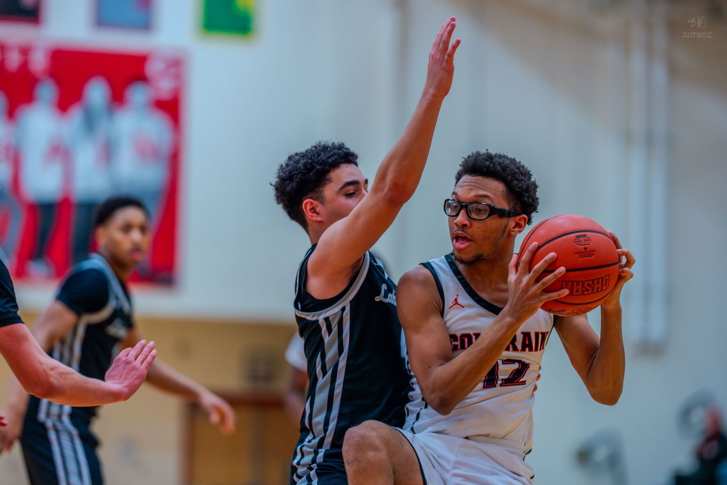 Colerain #12 drives to the basket while being defended in a high school basketball game.