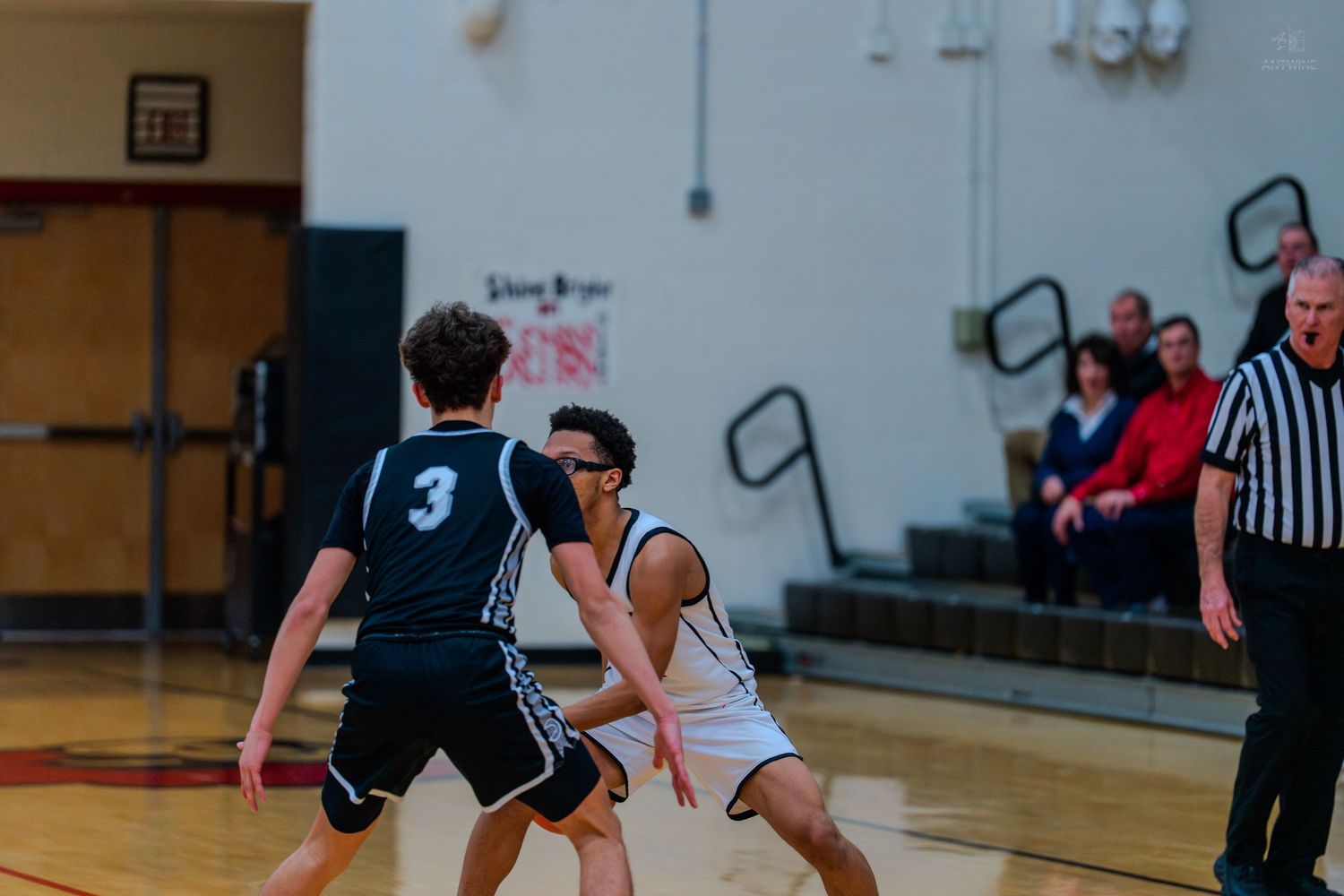 High school basketball players compete in defensive play during game.