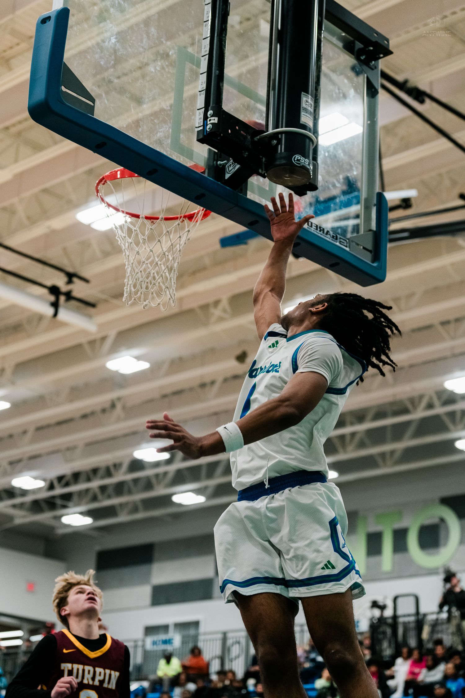 Warriors player #1 goes up for a slam dunk against Turpin defenders in a high school basketball game.