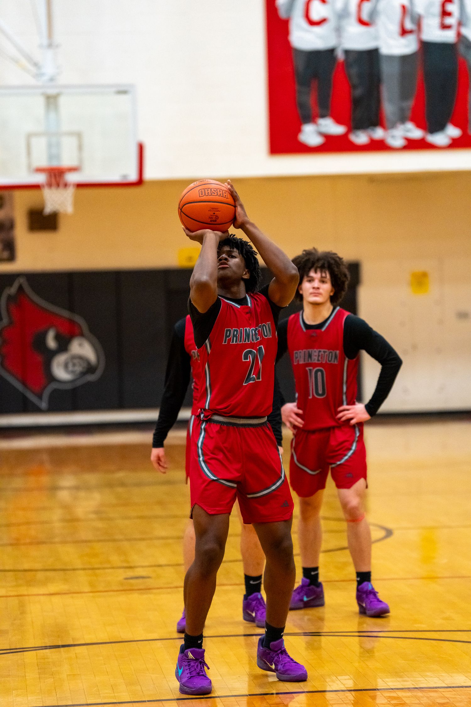 Princeton basketball player #21 shoots free throw while teammate #10 watches during high school game.