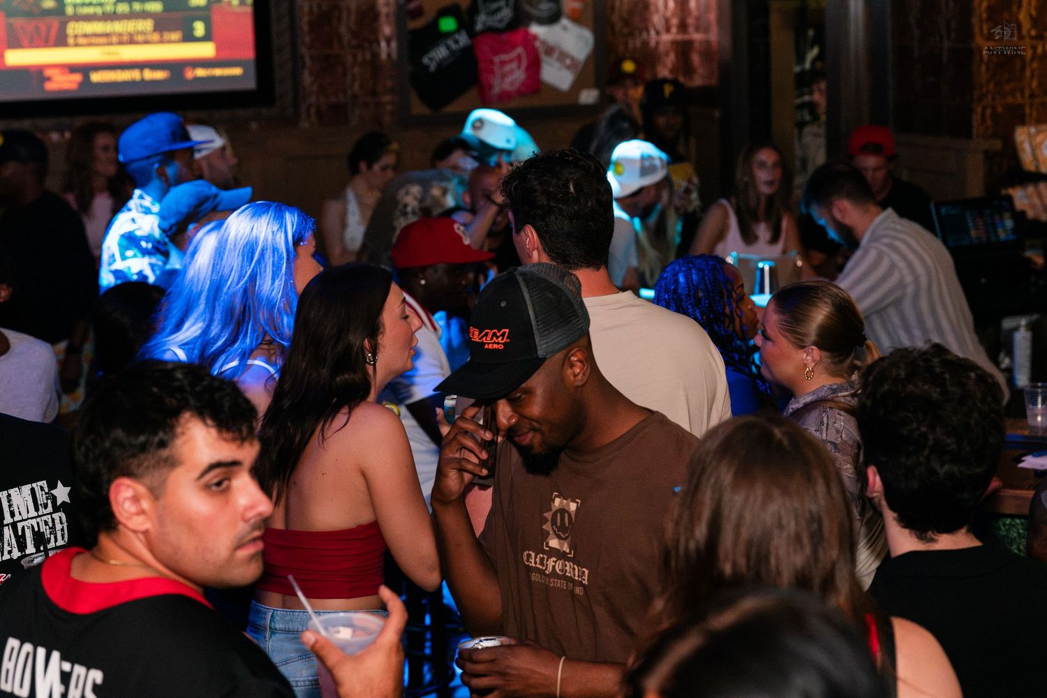 Diverse crowd of people dancing and socializing at a lively nightclub event.