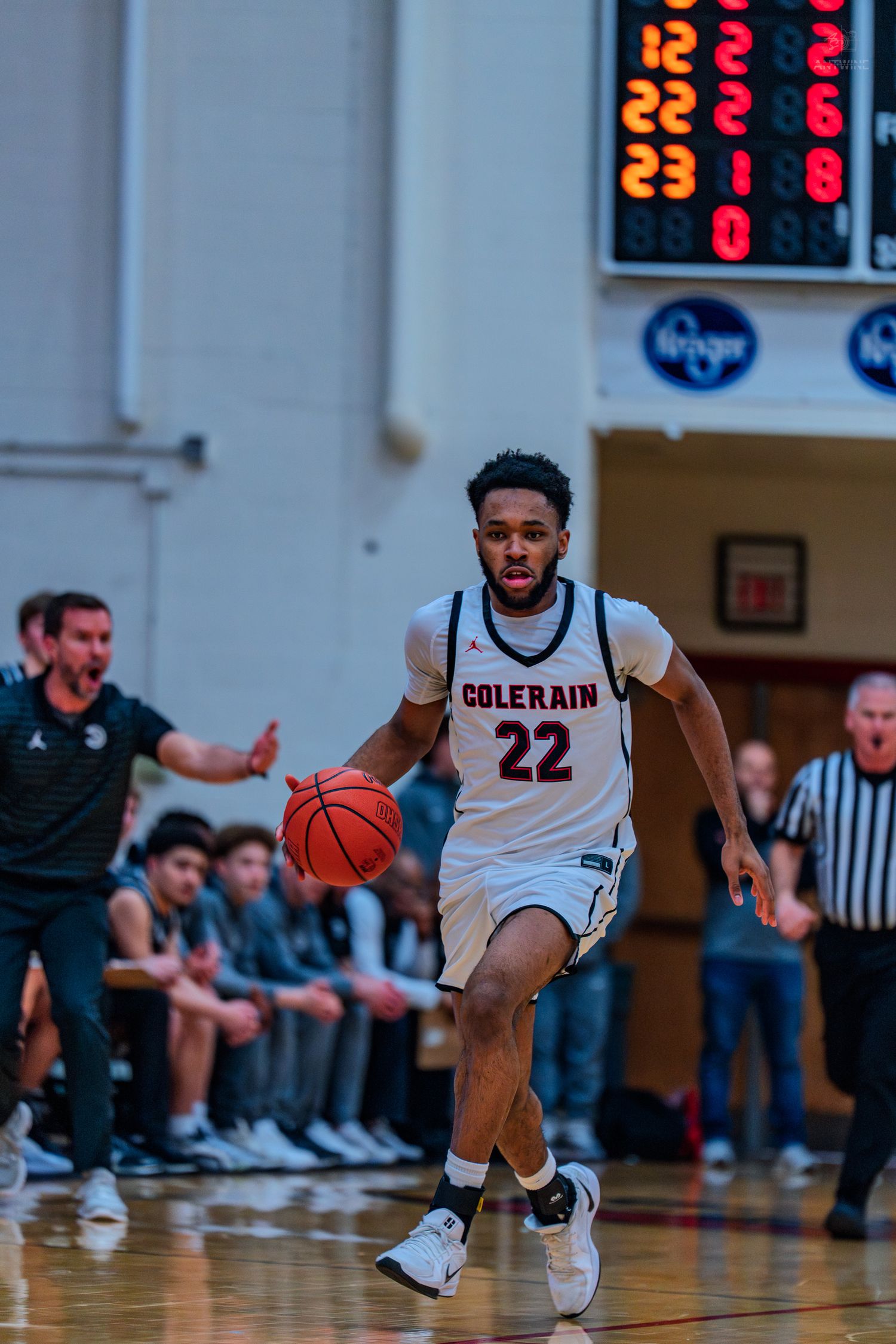 Colerain #22 basketball player dribbles up court during a high school game.