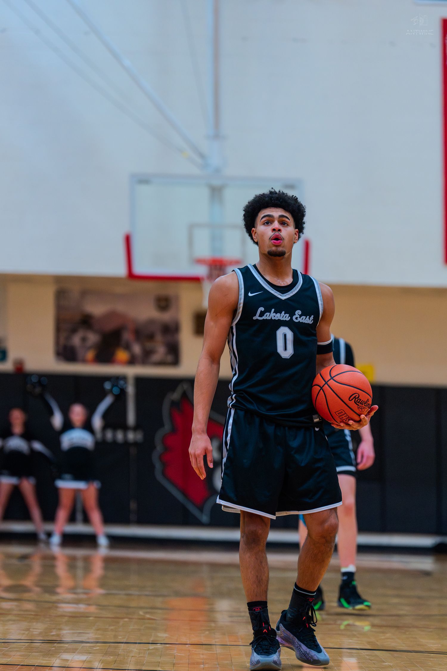 Lakota East basketball player #0 dribbles ball during high school game.