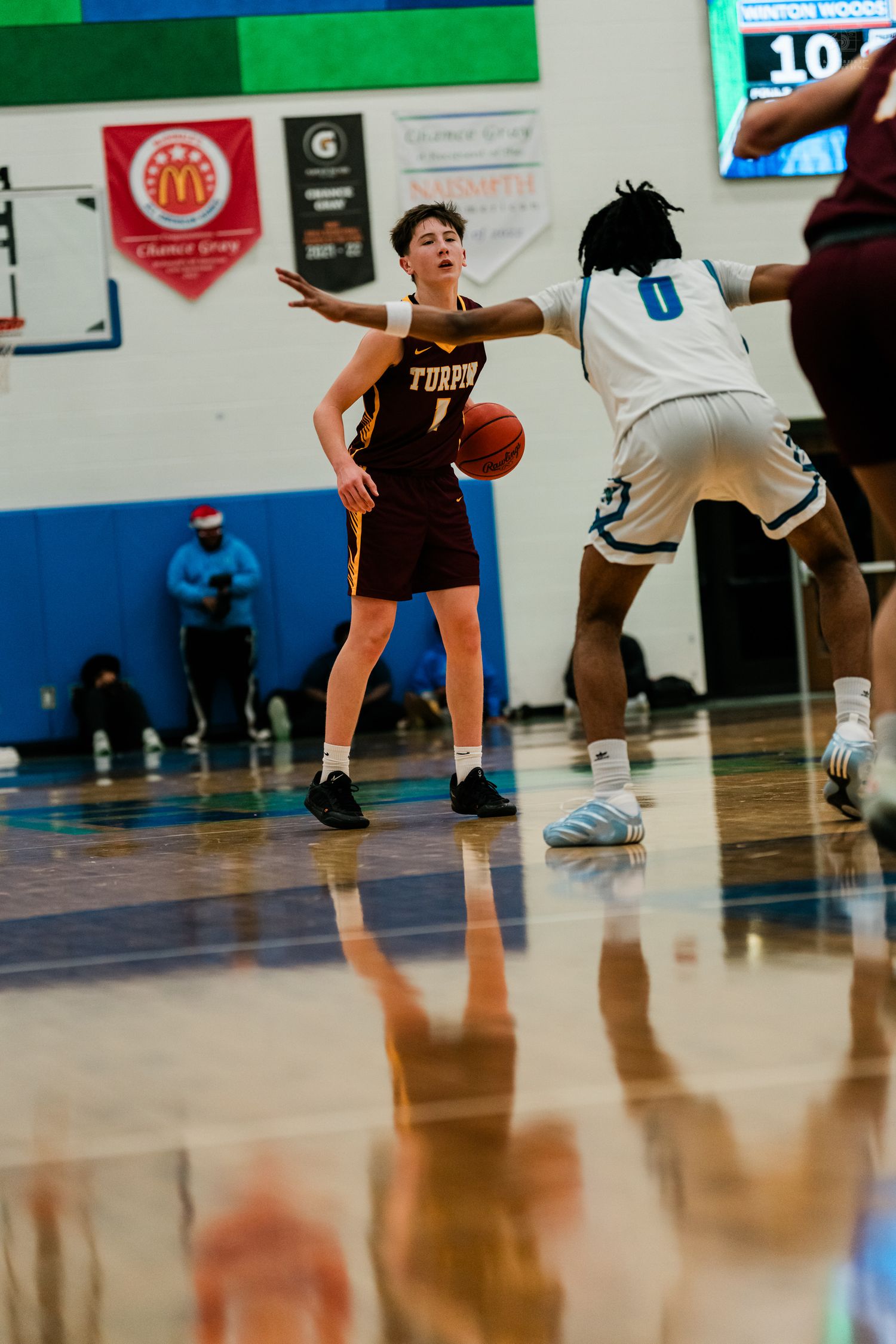 Turpin basketball player number 1 signals to teammates while being guarded by defender wearing number 0 jersey.