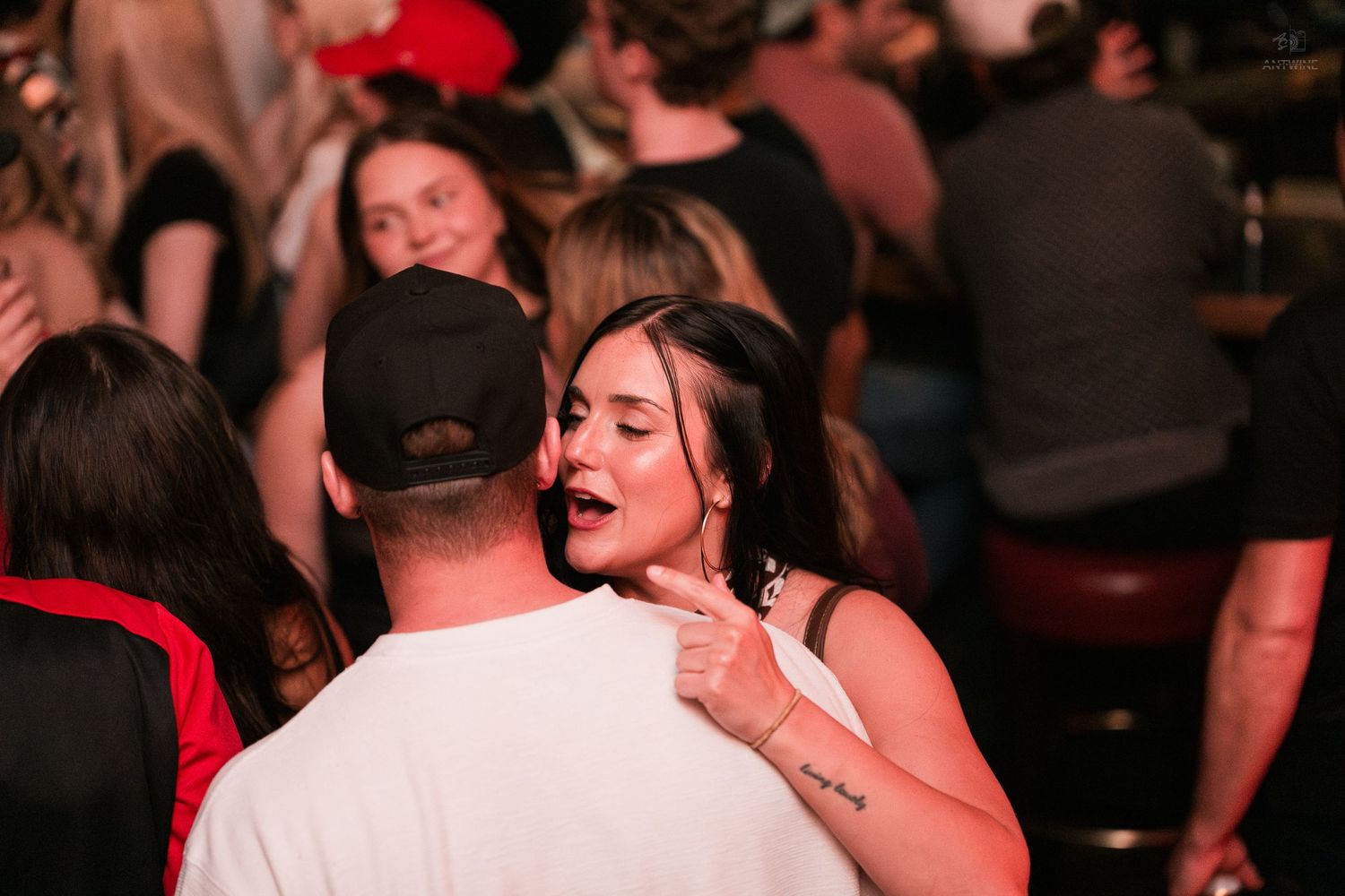 Couple embracing and dancing closely at a lively nightclub event.